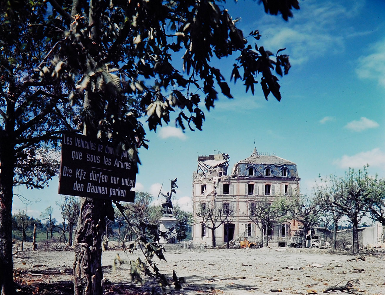 Ruined building and sign in French and German, northwestern France, summer 1944.