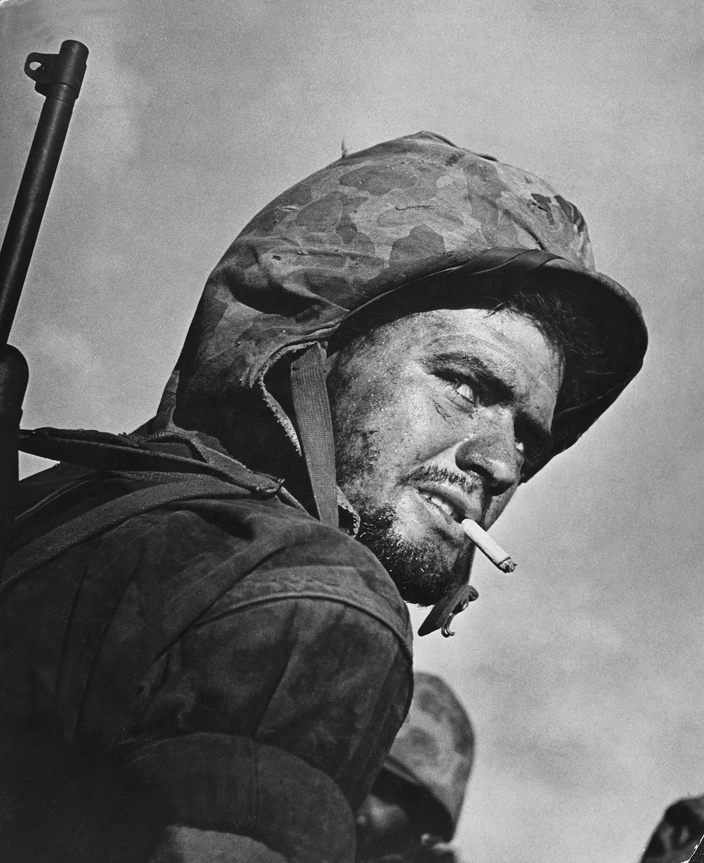A grizzled, battle-weary Marine peers over his shoulder during the final days of fighting on Saipan, July 1944. (Nick Oza—Arizona Republic)