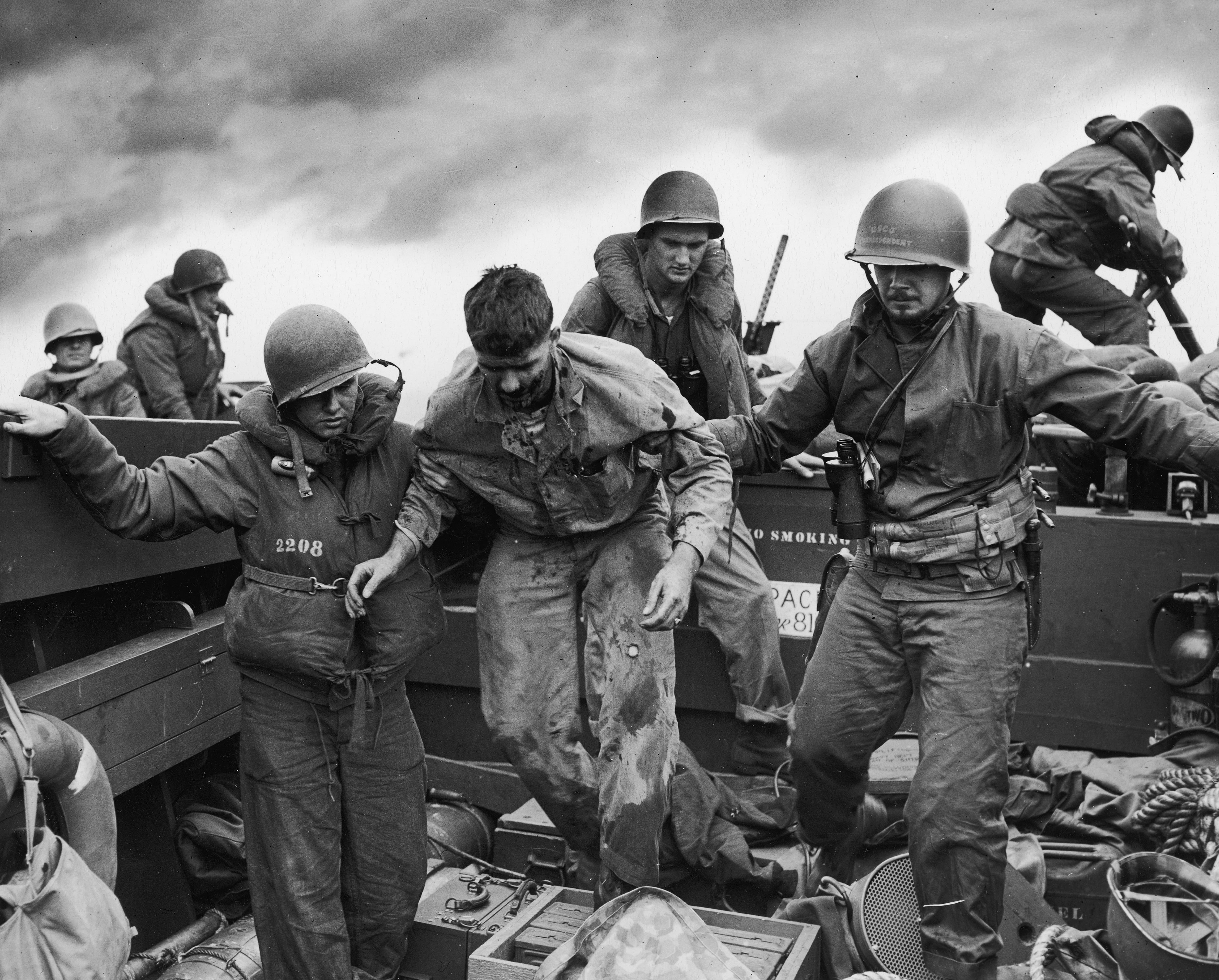 U. S. Coast Guardsmen assist a wounded Marine returning from the fight on Iwo Jima, 1945.