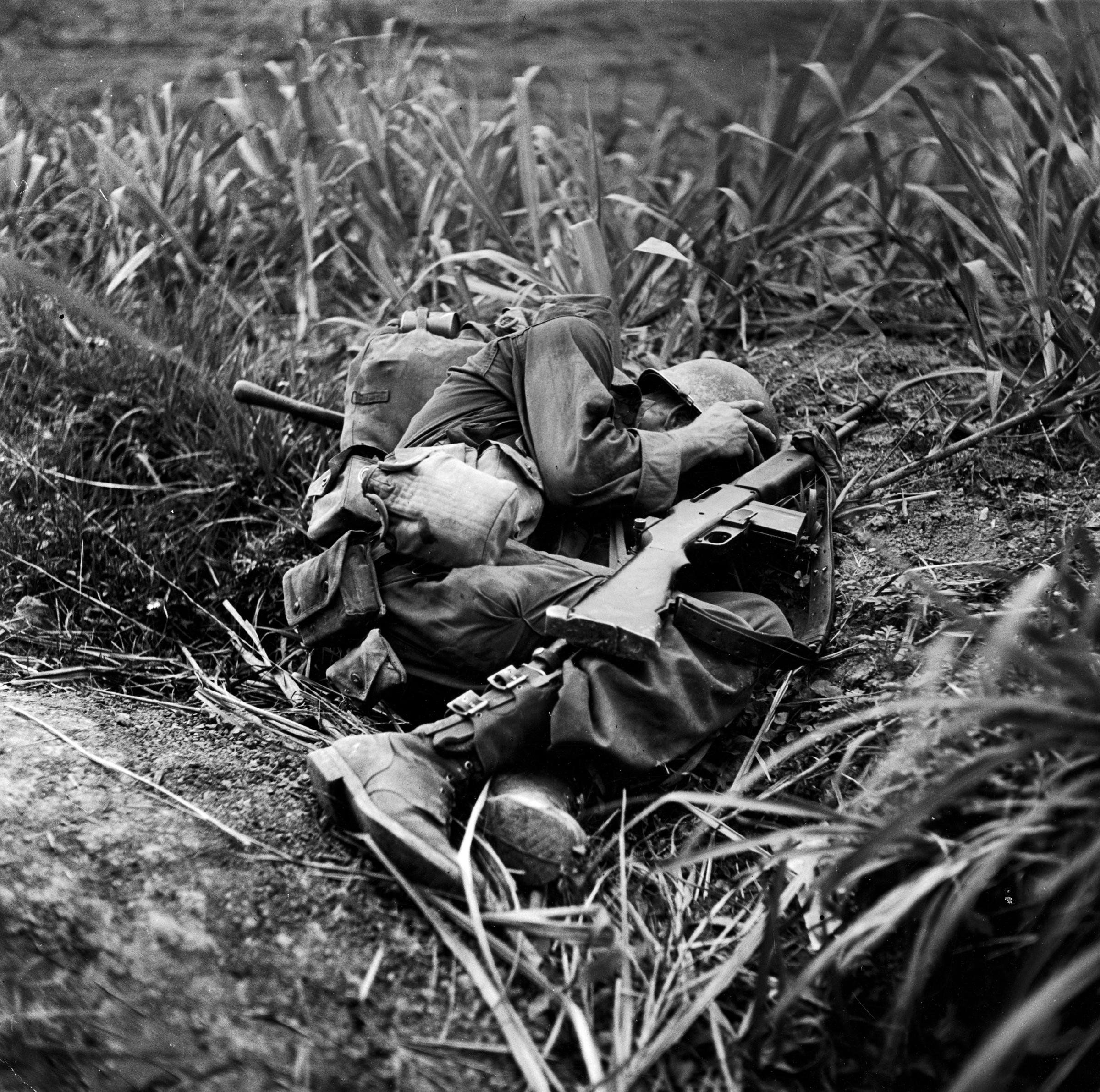 American infantryman Terry Moore takes cover as incoming Japanese artillery fire explodes nearby during the fight to take Okinawa, May 1945.