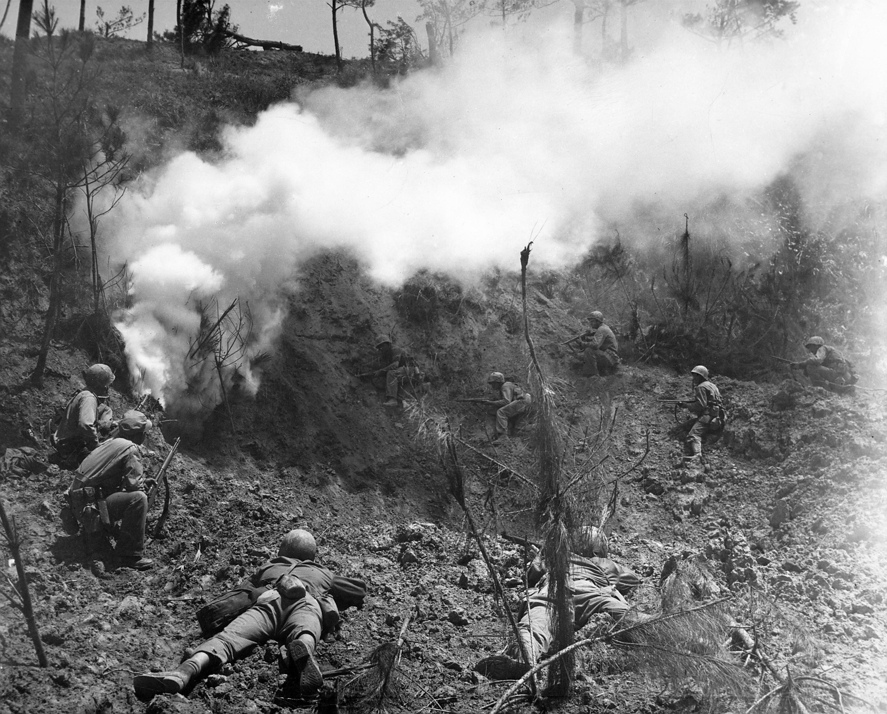 U.S. Marines wait to pick off enemies who flee cave after it was attacked with an explosive charge during the vicious fight for control of Okinawa, 1945.