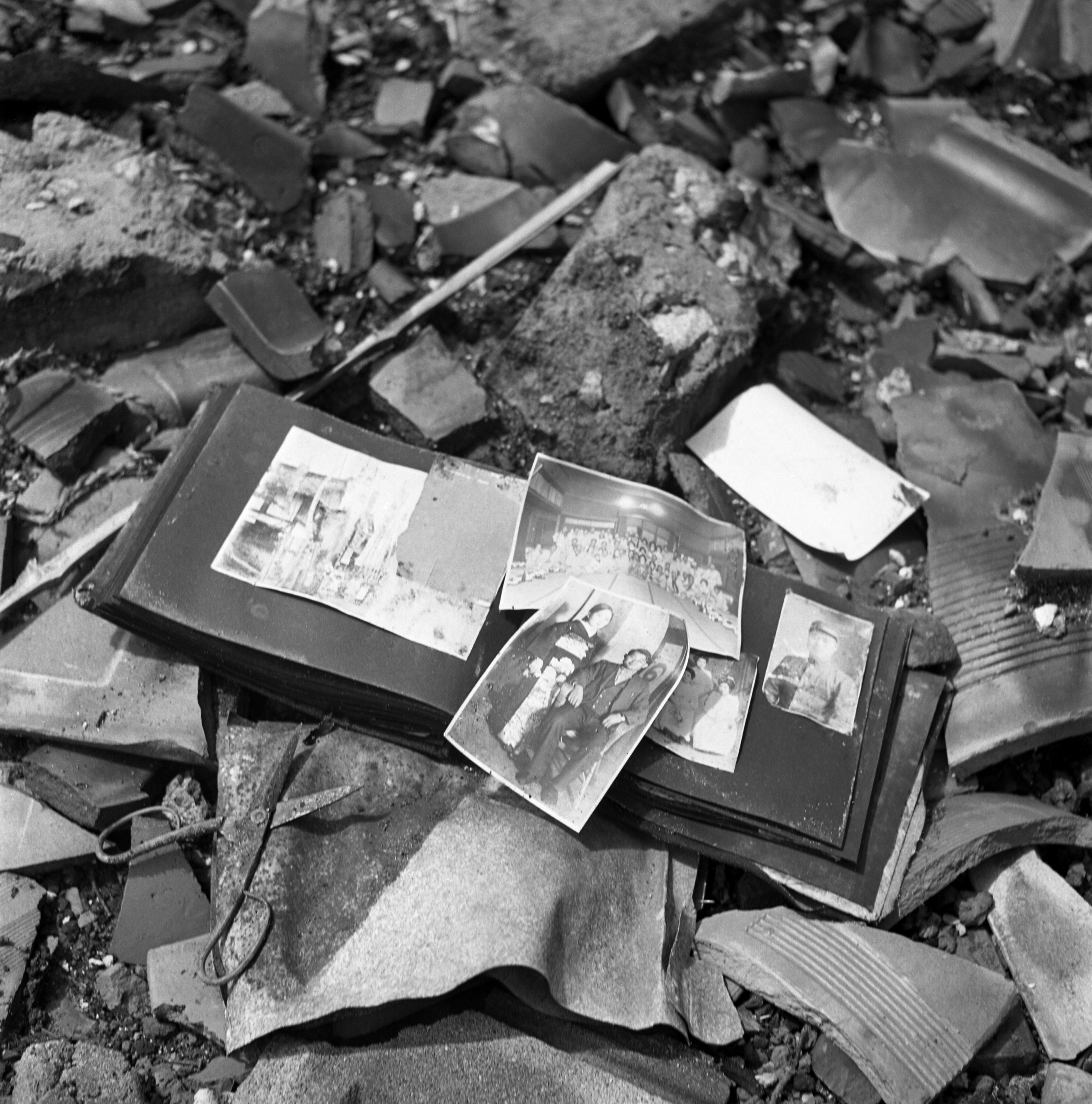 A photo album, pieces of pottery, a pair of scissors — shards of life strewn on the ground in Nagasaki, 1945.