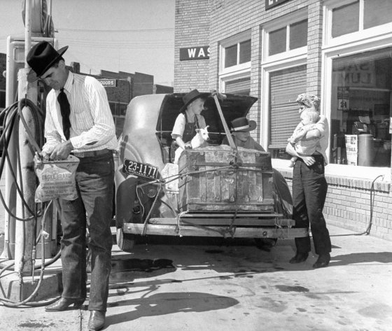Driver filling a water bag at a gas station alongside Route 30, 1948.