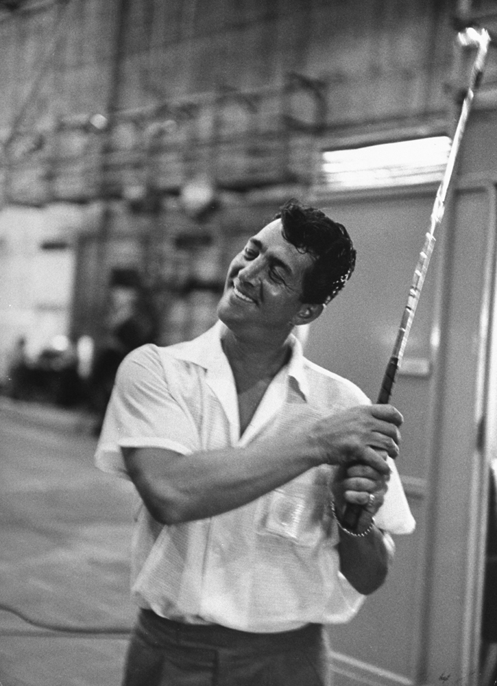 Dean Martin swings a golf club in order to stay loose on set of the film, Some Came Running, 1958.