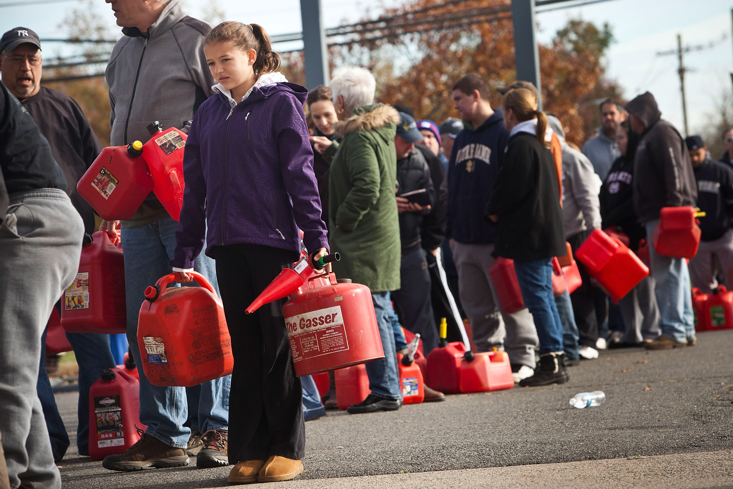 A girl holds jerry cans while waiting in line at a gas station in Hazlet township, N.J., Nov. 1, 2012. (Andrew Burton—Getty Images)