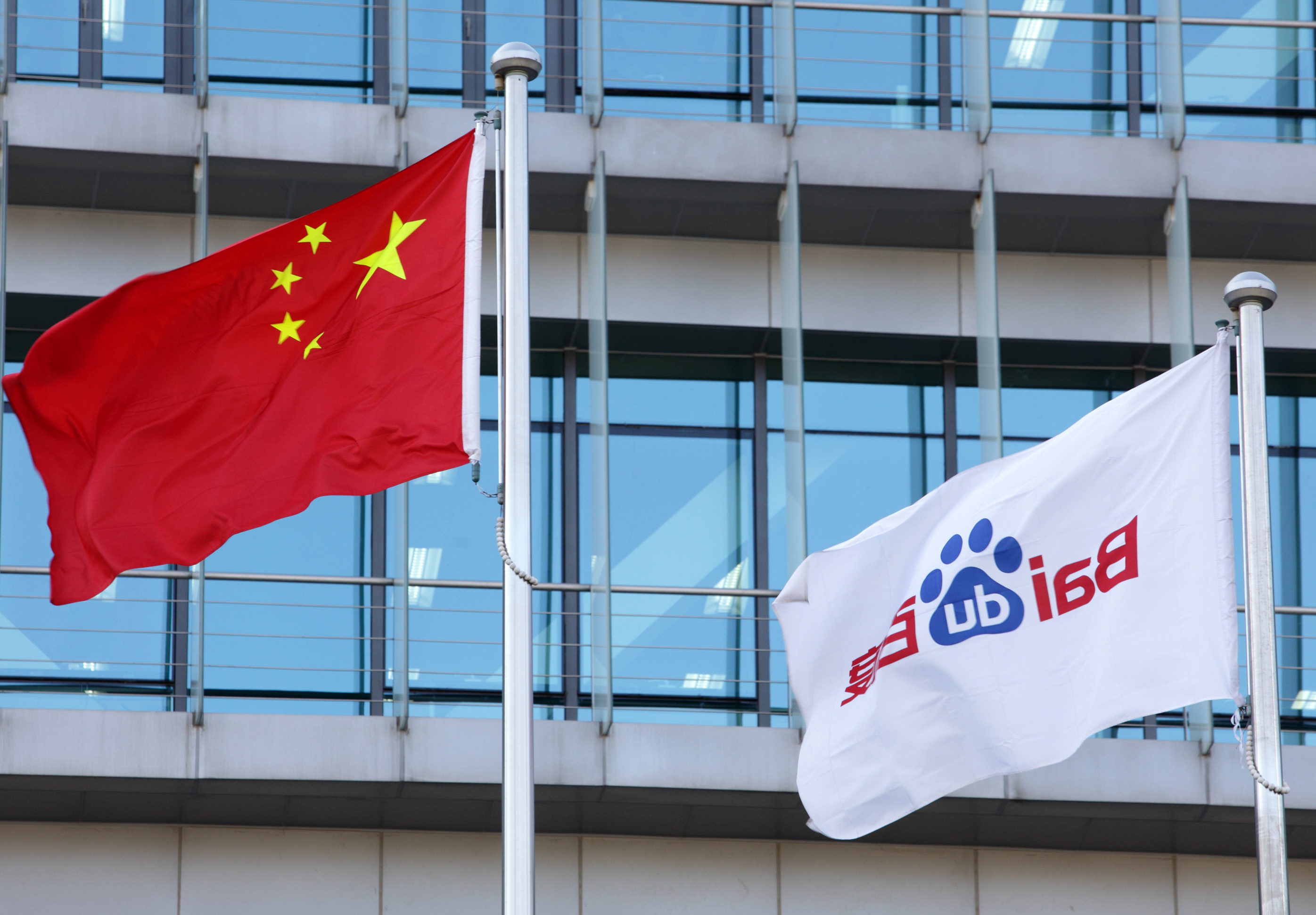 China's national flag, left, and Baidu Inc.'s corporate flag fly outside Baidu's headquarters in Beijing, China, on Monday, Nov. 12, 2012. (Tomohiro Ohsumi—Bloomberg/Getty Images)