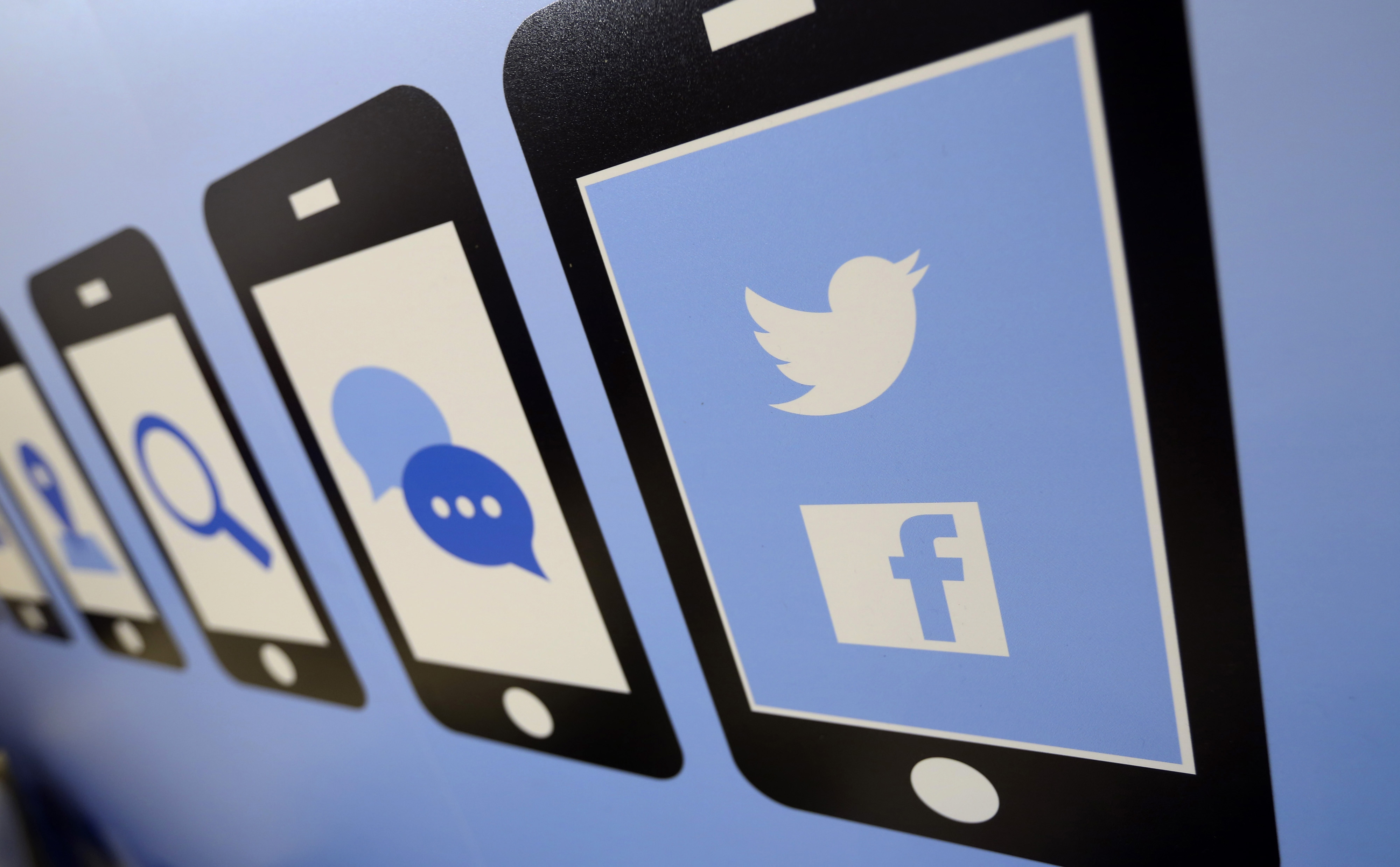 The Facebook Inc. and Twitter Inc. company logos are seen on an advertising sign during the Apps World Multi-Platform Developer Show in London, U.K., on Wednesday, Oct. 23, 2013. (Bloomberg/Getty Images)