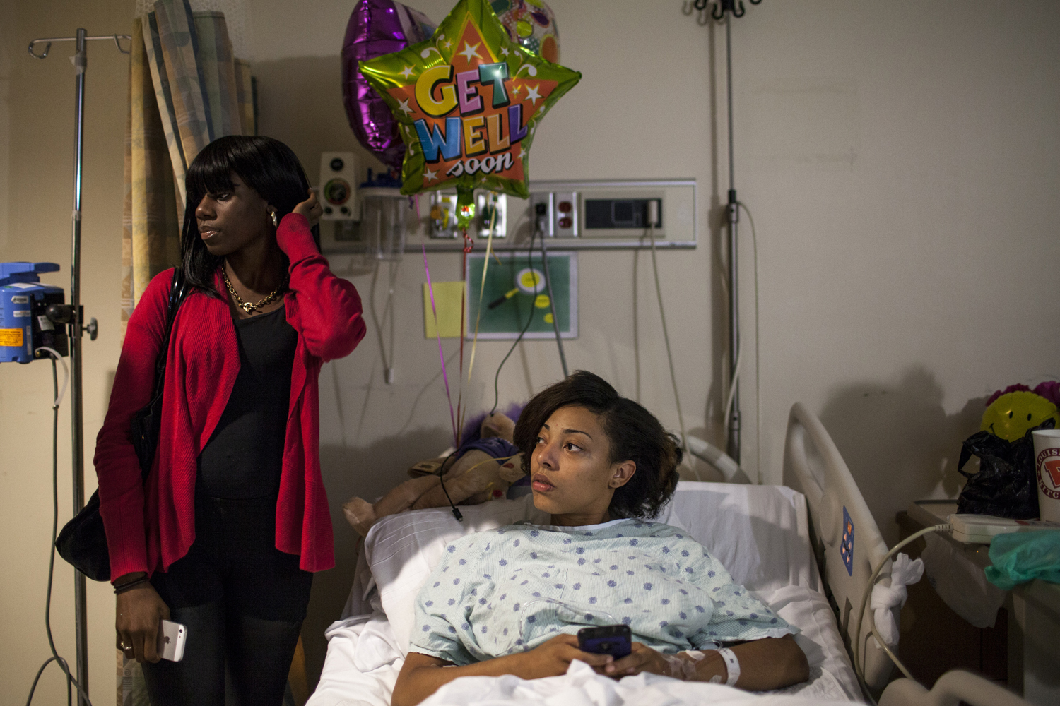 October 2, 2013. Sarah, medicated on high doses of pain killers, lies in a hospital bed surrounded by friends and get well soon gifts, the day after she was shot in the foot outside her family's home in East Flatbush. She heard shots and started to run, but a bullet ricocheted off the sidewalk  and lodged in her heel. It had to be surgically removed.