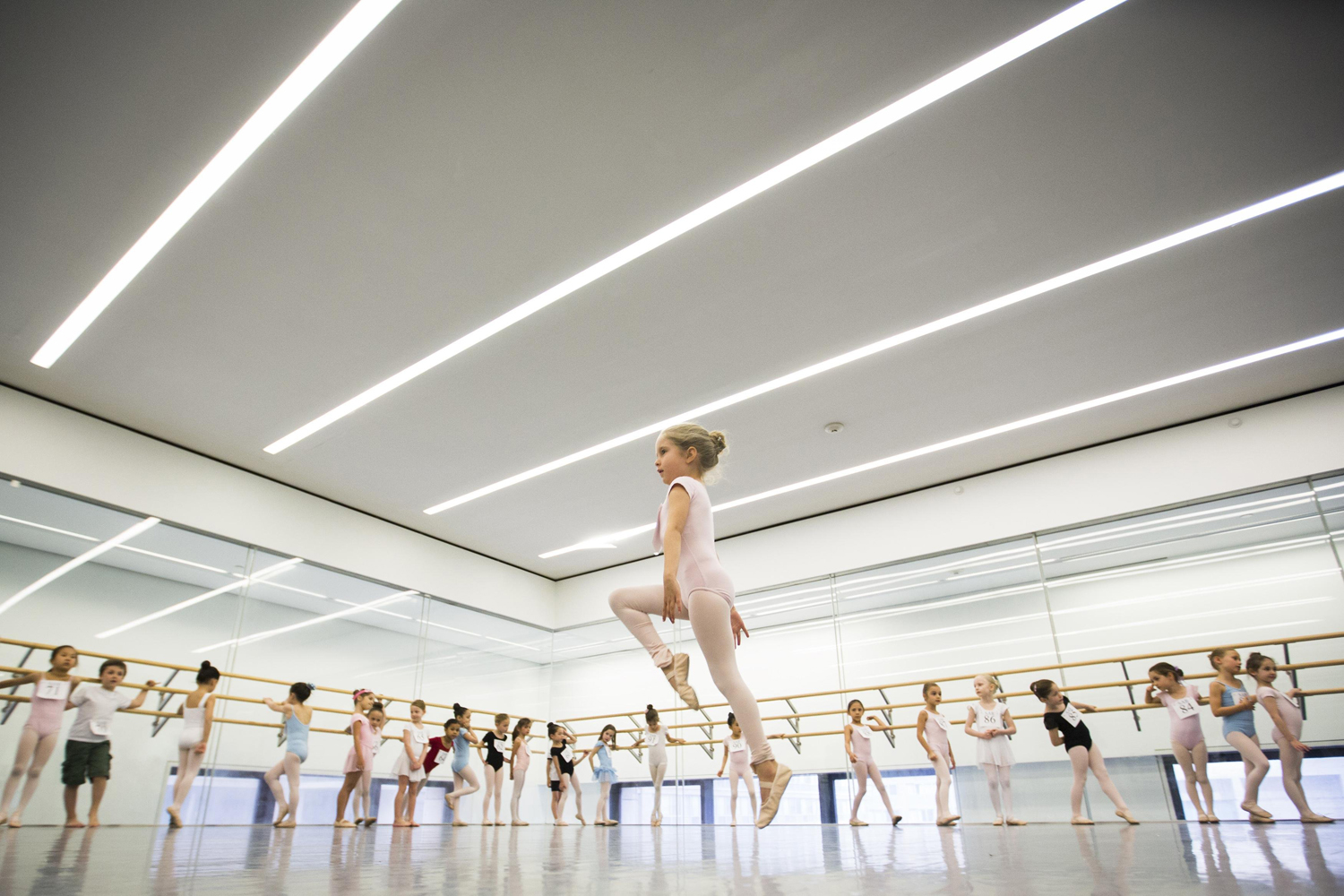 Children watch as a girl dances during an audition for the School of American Ballet in New York