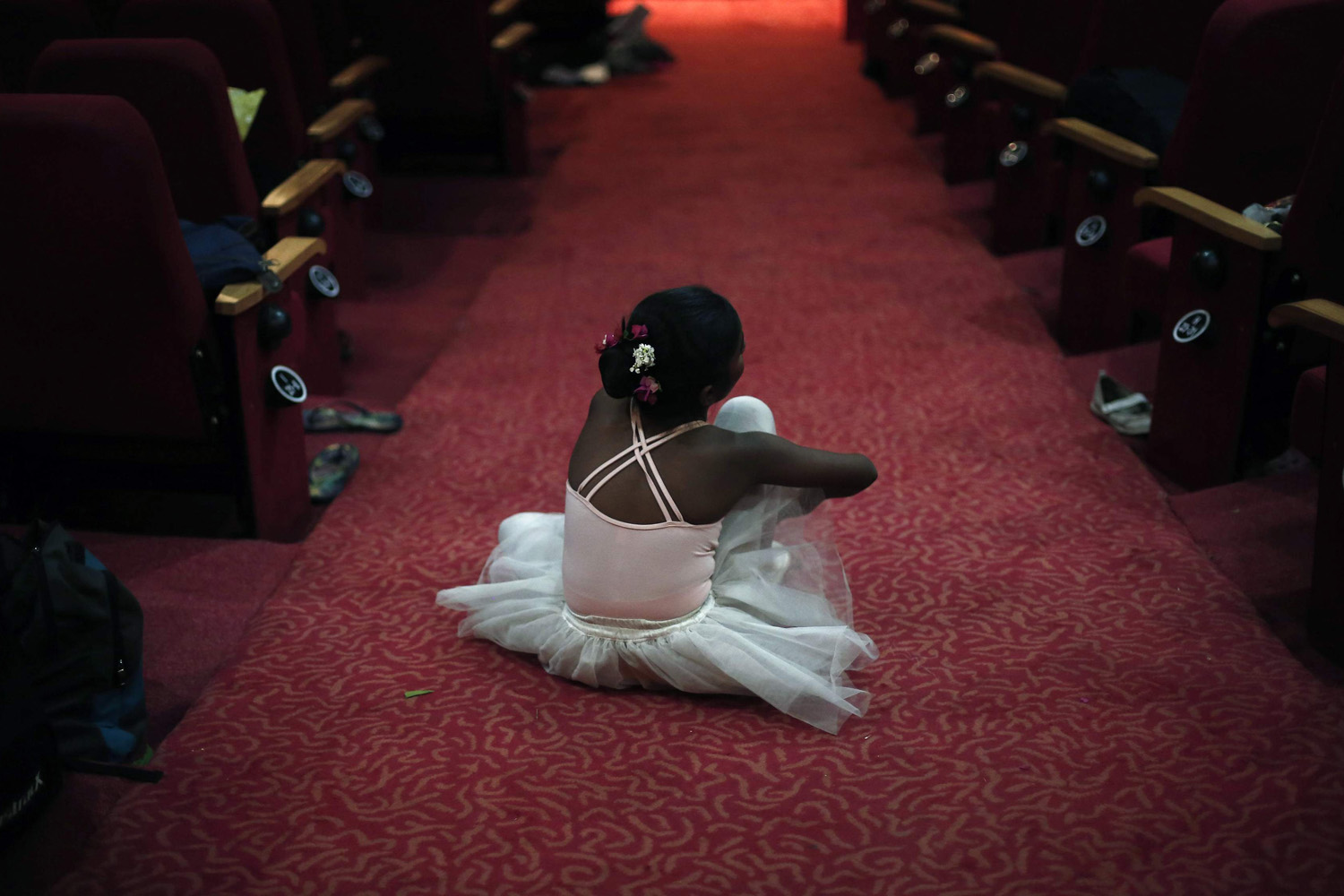 A girl sits backstage after getting ready for her dance recital to celebrate International Dance Day, in New Delhi