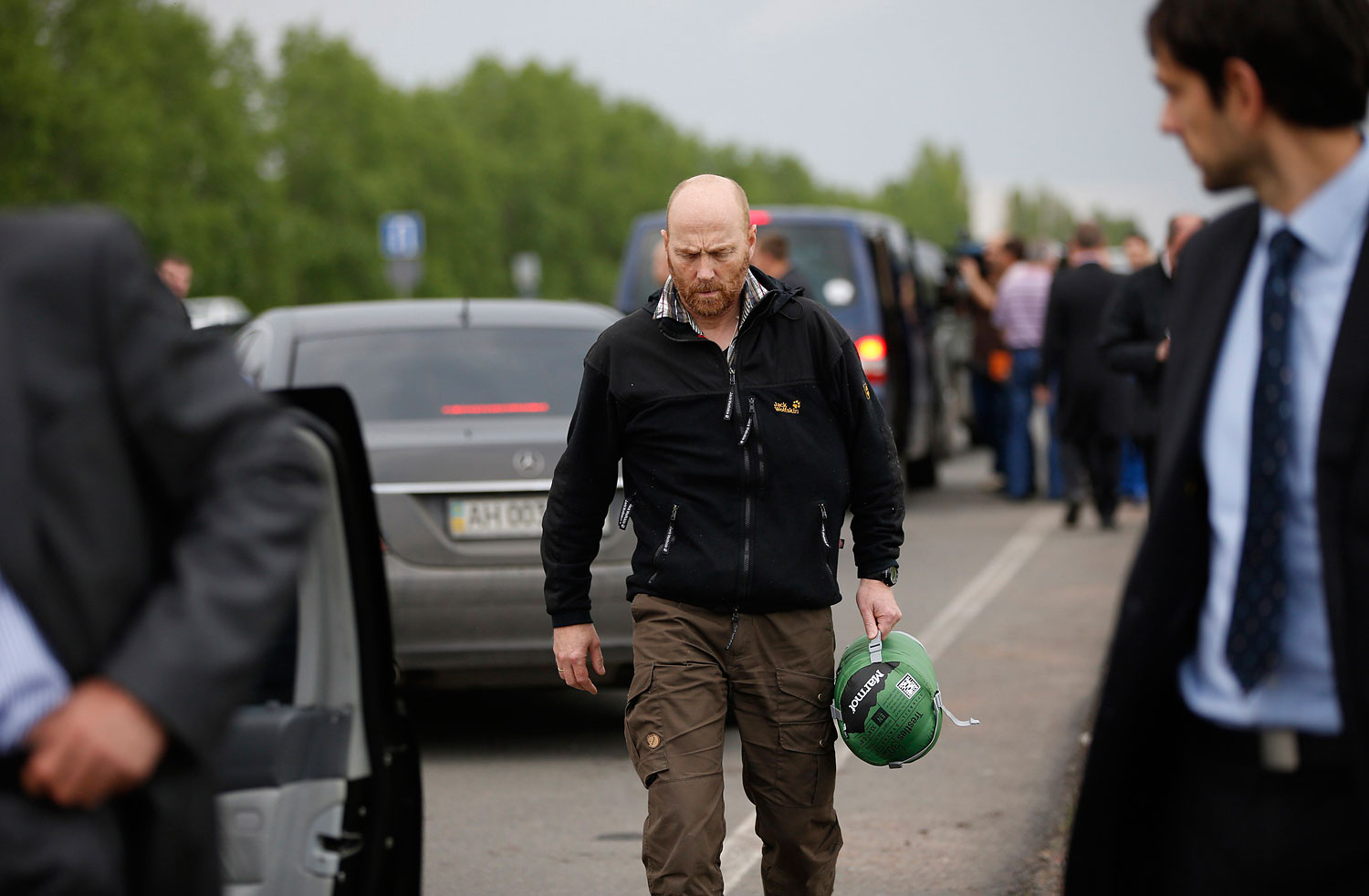 OSCE observer Schneider walks among colleagues on a road 30 km (19 miles) from Donetsk after being freed by pro-Russian separatists