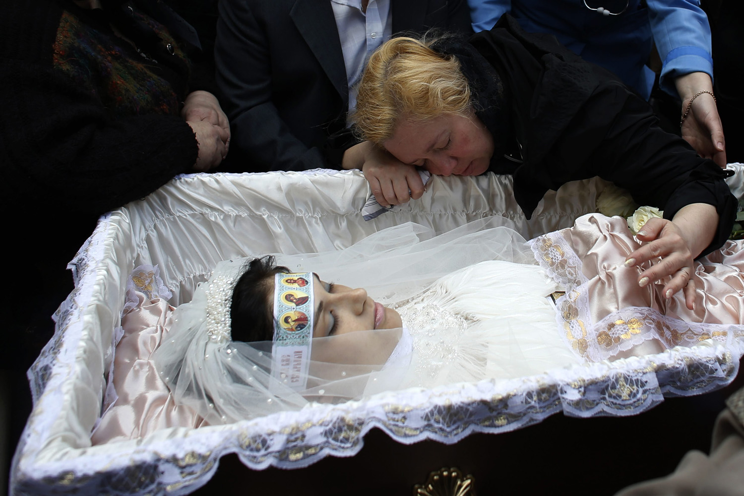 Mother of 21-year-old nurse Yulia Izotova mourns at her funeral in Kramatorsk, eastern Ukraine