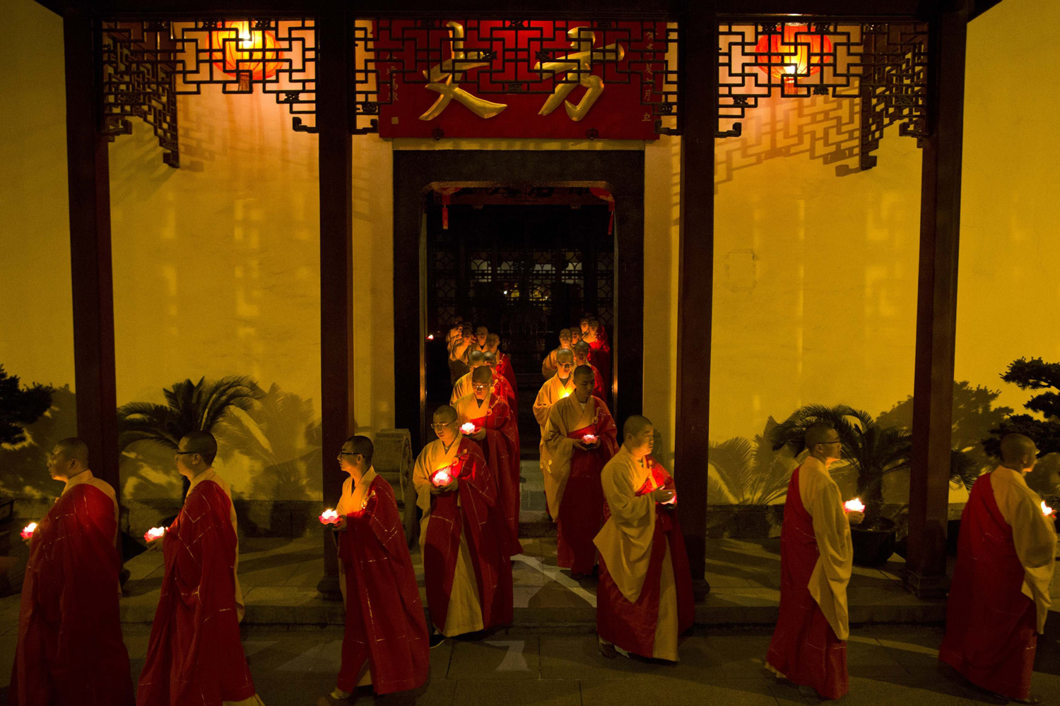 Monks hold candles as they pray during a ceremony to celebrate Buddha's birthday at the Yufo Temple in Shanghai