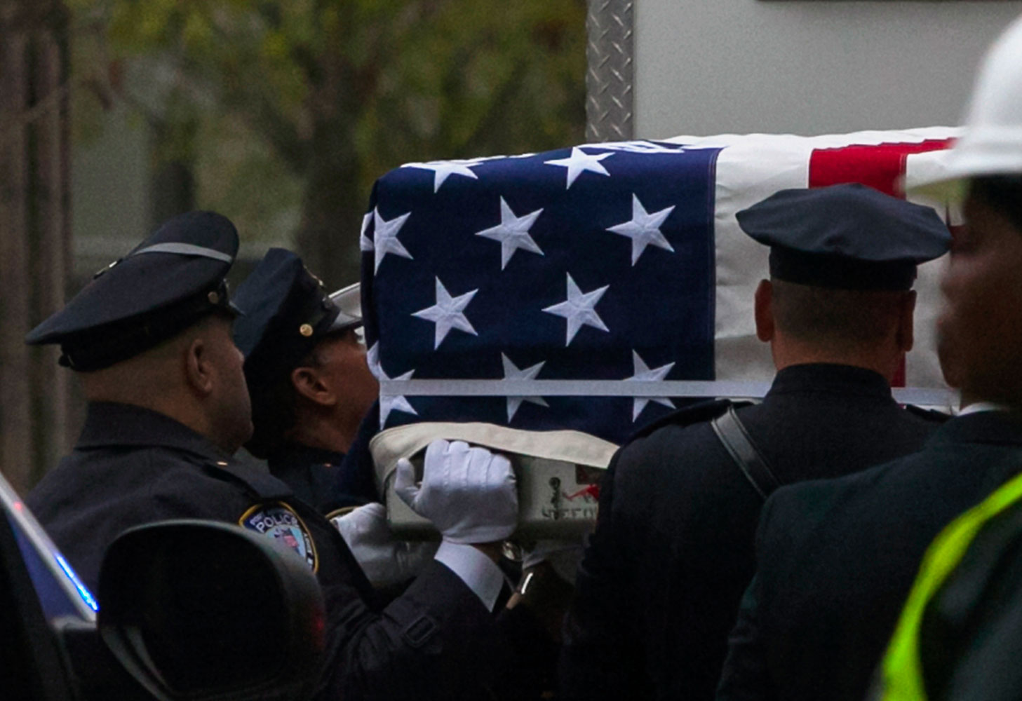 Emergency personnel carry a casket draped with a U.S. flag during the ceremonial transfer of the 9/11 unidentified remains to the OCME repository at the World Trade Center site, in New York