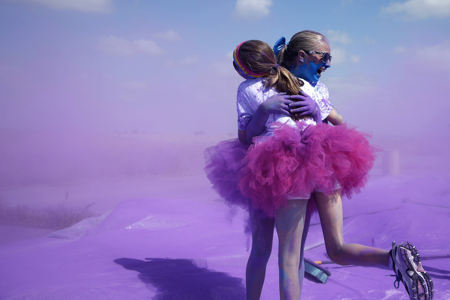 Competitors hug after running through colored powder at the Orange County Color 5K Run in Irvine, Calif., on May 10, 2014.