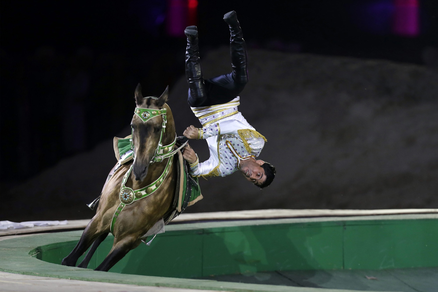 A Turkmenistan man performs on a horse during the opening ceremony of 2014 International Akhal-Teke Horses Association Special Conference and China Horse Culture Festival in Beijing