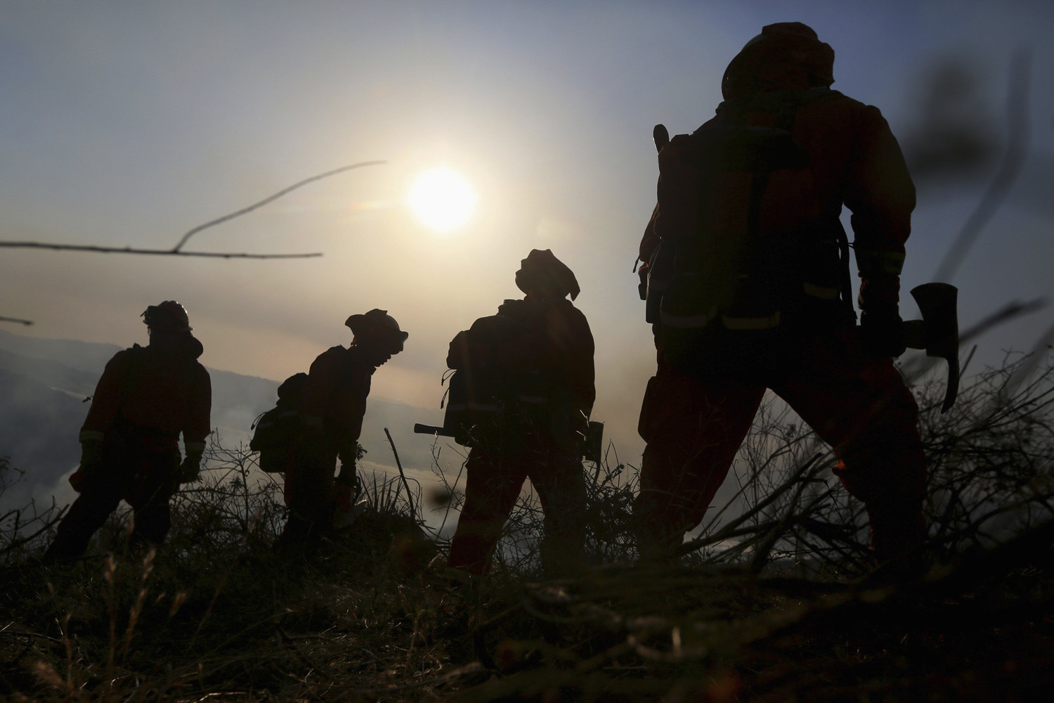 A prison crew battles a fire in an avocado grove outside Fallbrook, California