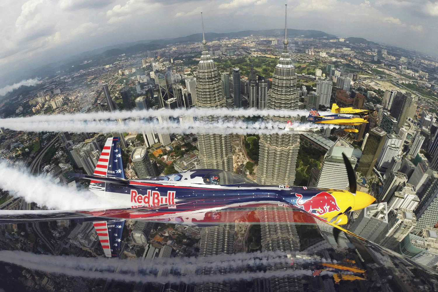 Kirby Chambliss of the U.S. flies in formation with Matt Hall of Australia, Yoshihide Muroya of Japan and Nigel Lamb of Britain prior to the third stage of the Red Bull Air Race World Championship in front of the Petronas Towers in Kuala Lumpur May 15, 2014.