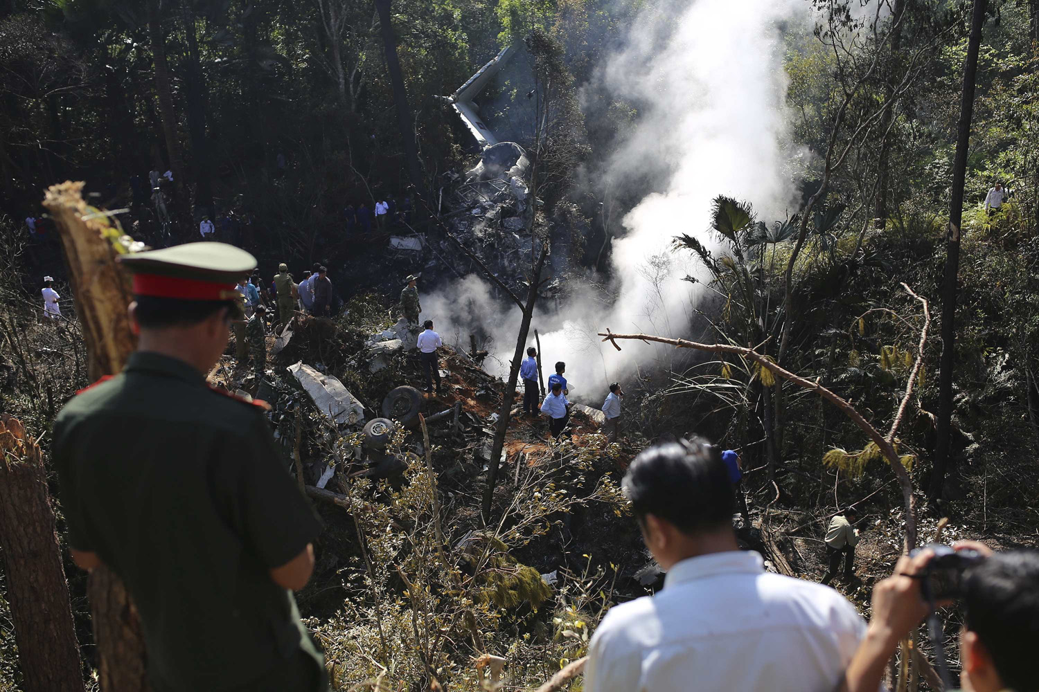 Rescue workers search an air force plane crash site near Nadee village, in Xiang Khouang province