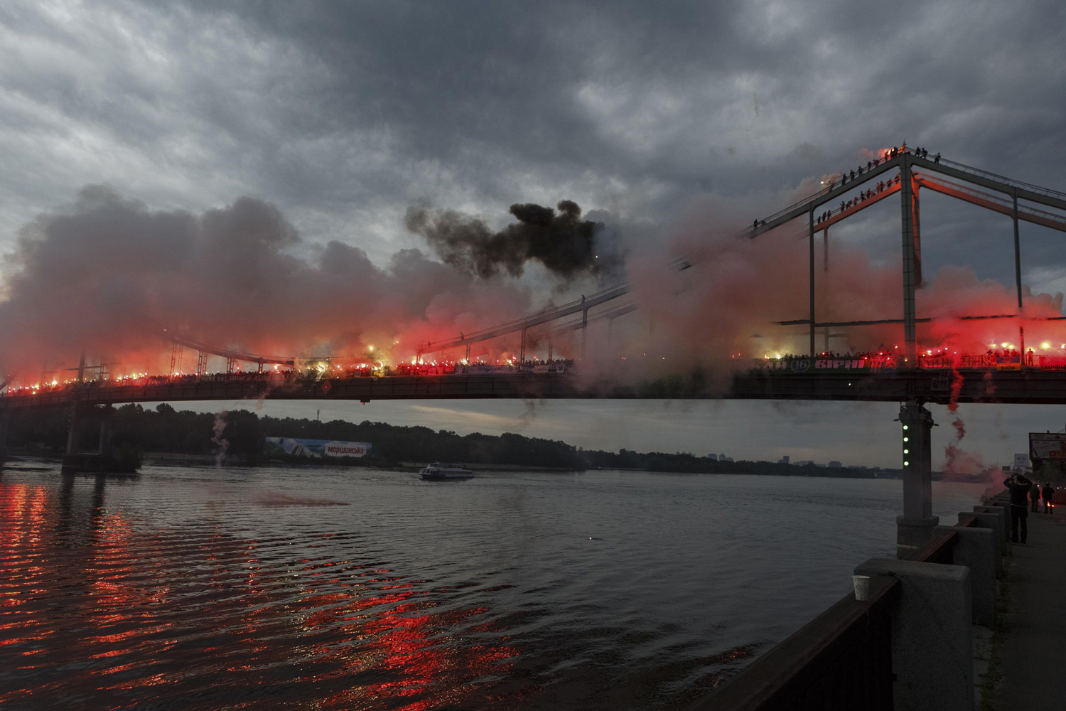 Ukrainian soccer fans light flares on a bridge across the Dnieper River in Kiev, Ukraine on May 18, 2014.