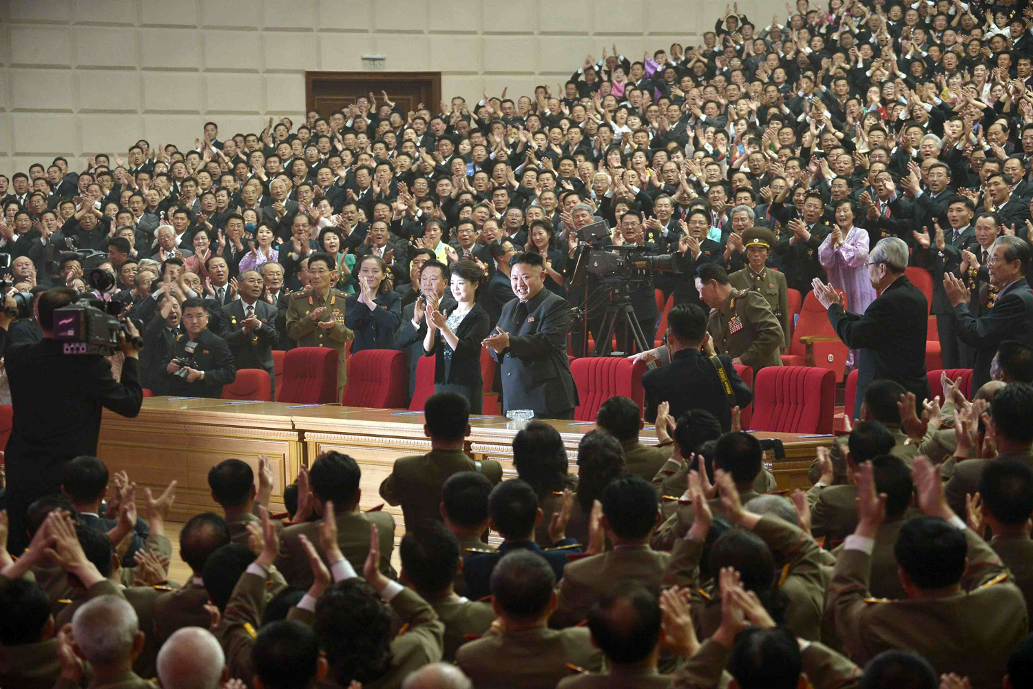 May 20, 2014. North Korean leader Kim Jong Un (C) accompanied by his wife Ri Sol Ju (centre L) applaud as they attend an art performance by the Moranbong Band at the  House of Culture in Pyongyang.