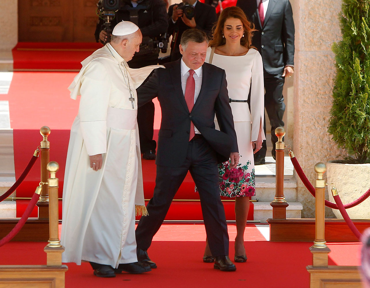 Jordan's King Abdullah and Queen Rania walk with Pope Francis during a welcoming ceremony in Amman