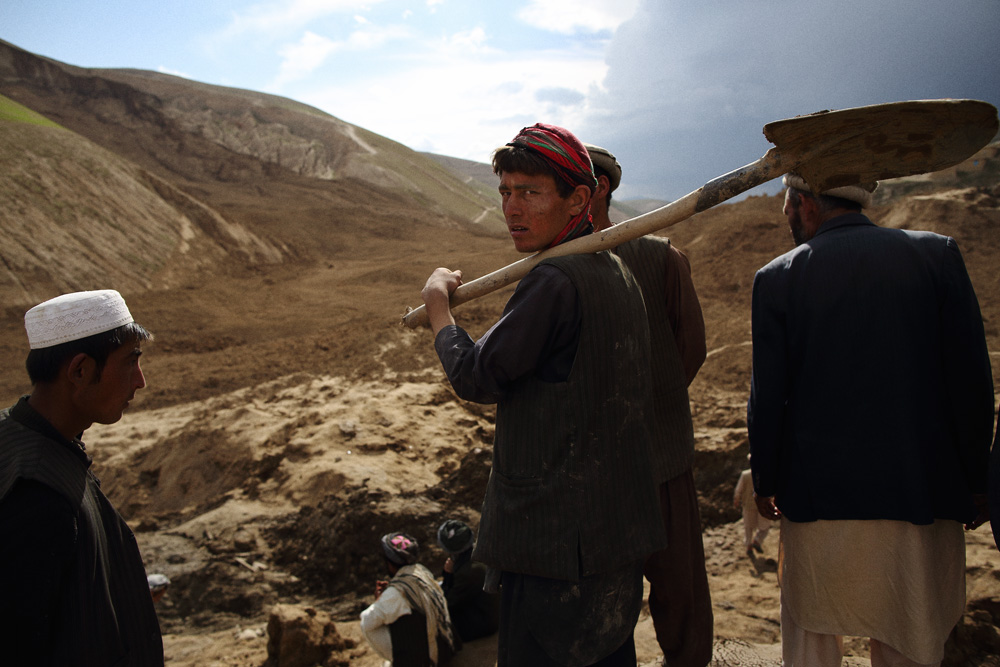 Approximately 24 hours after 2 landslides buried over 2000 residents of Argo district in the mountainous northeastern state of Badakhshan under hundreds of feet of mud. The first landslide buried some 300 homes and those who had been inside or on the streets at the time as well as those attending a wedding party. The second landslide struck as villagers attempted to rescue those trapped - digging with shovels and their bare hands. Today - Saturday - rescuers called off a search for survivors due to a lack of heavy machinery required for the massive task. Mohammad Karim Khalili, one of Afghanistan’s two Vice Presidents along with a handful of ministers travelled from Kabul to pay their respects at the site of the landslide today. Saturday 3 May, 2014. Photo by Andrew Quilty / Oculi for TIME. A young man carries a shovel as many others did but few used them - the task beyond hope. Saturday 3 May, 2014. Photo by Andrew Quilty / Oculi for TIME.
