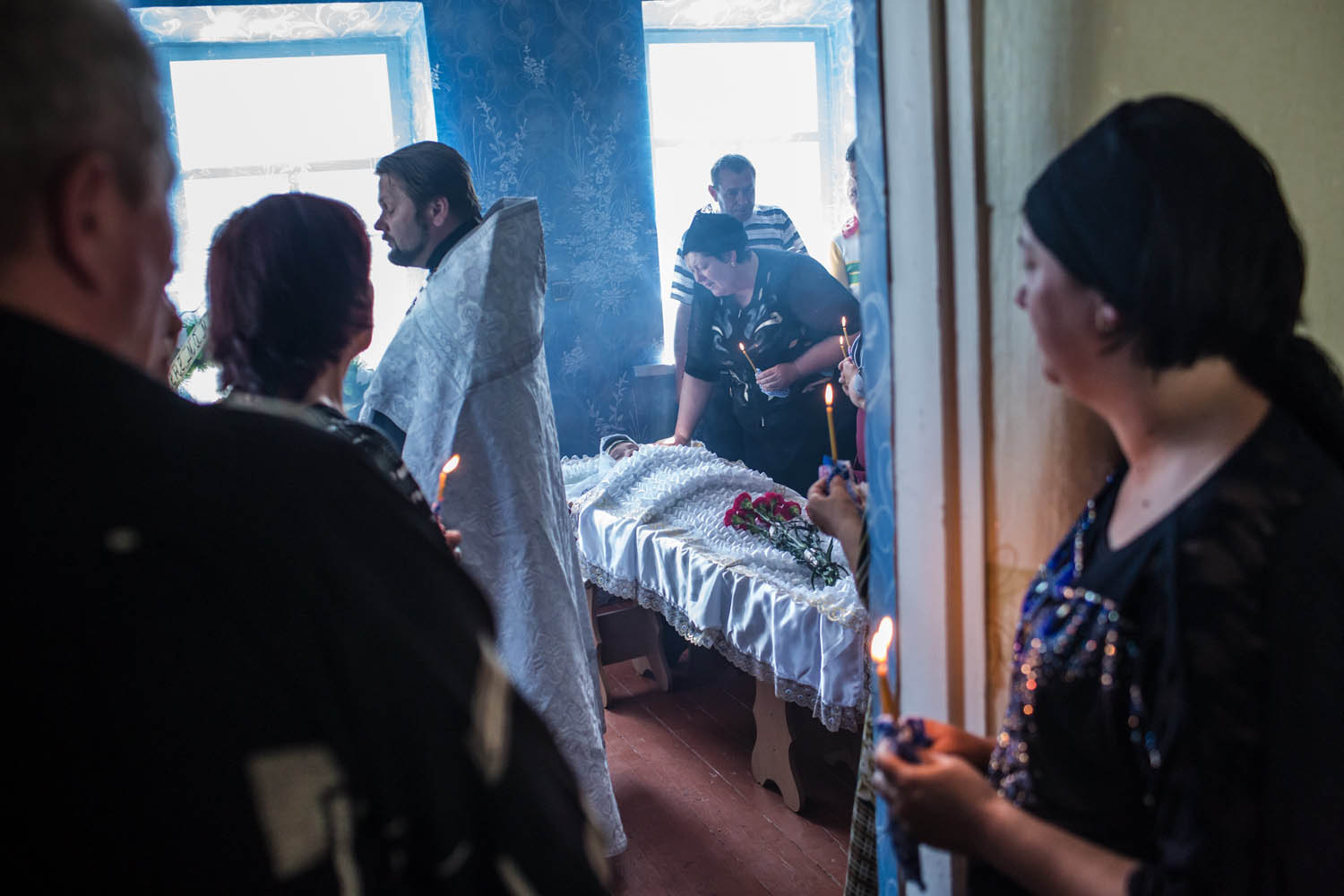 May 16, 2014. Mourners attend the funeral of Elena Ott, 42, in Starovarvarovka, Ukraine. Ott was killed two days prior when the car she was riding in was fired on by forces her family believes to be the Ukrainian military.