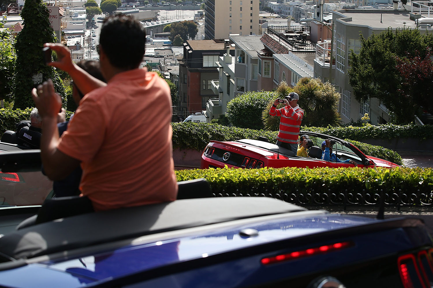 Tourists take pictures while driving down Lombard Street in San Francisco, on May 20, 2014.