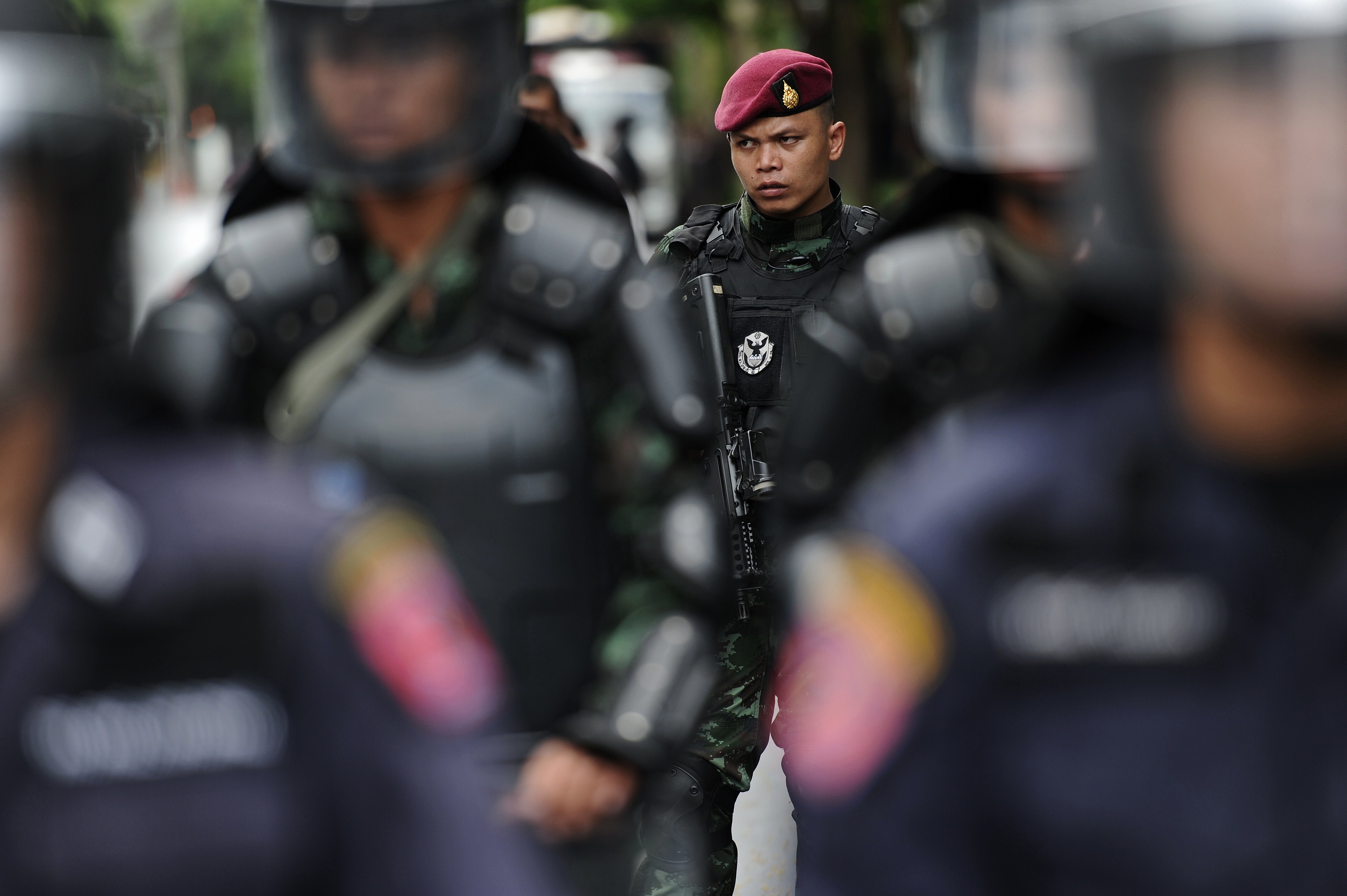 Members of the Thai security forces stand guard outside the Army auditorium in Bangkok where prominent figures including former Prime Minister Yingluck Shinawatra are reporting to the junta on May 23, 2014. (CHRISTOPHE ARCHAMBAULT—AFP/Getty Images)