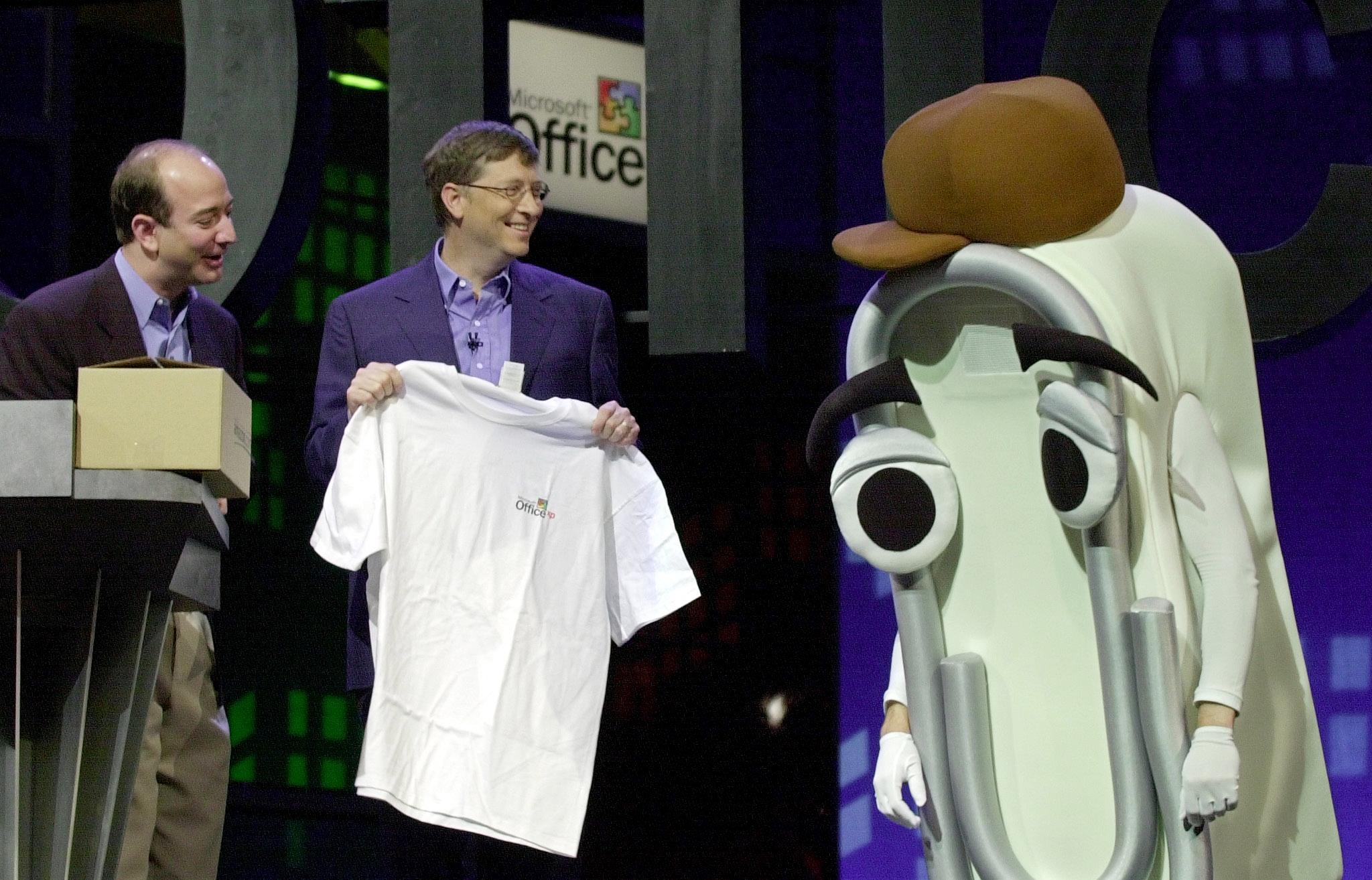 Microsoft CEO Bill Gates (C) presents a T-shirt as