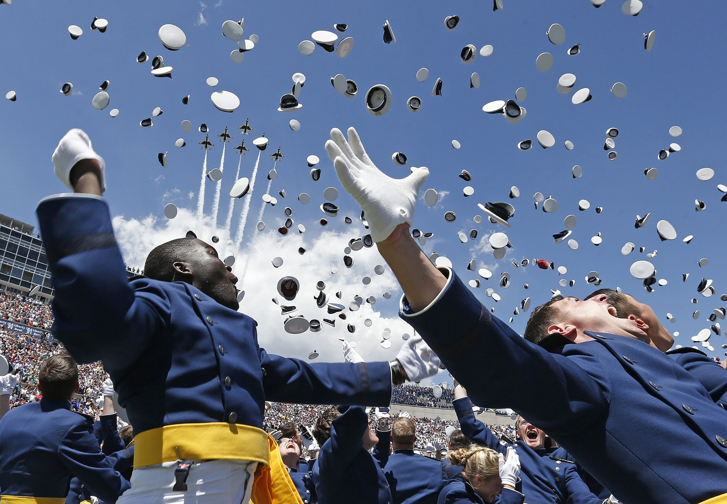 Air Force Academy graduates throw their caps into the air as F-16 jets from the Air Force group, The Thunderbirds, make a flyover at the completion of the graduation ceremony for the class of 2014 at the U.S. Air Force Academy in Colorado on May 28, 2014.