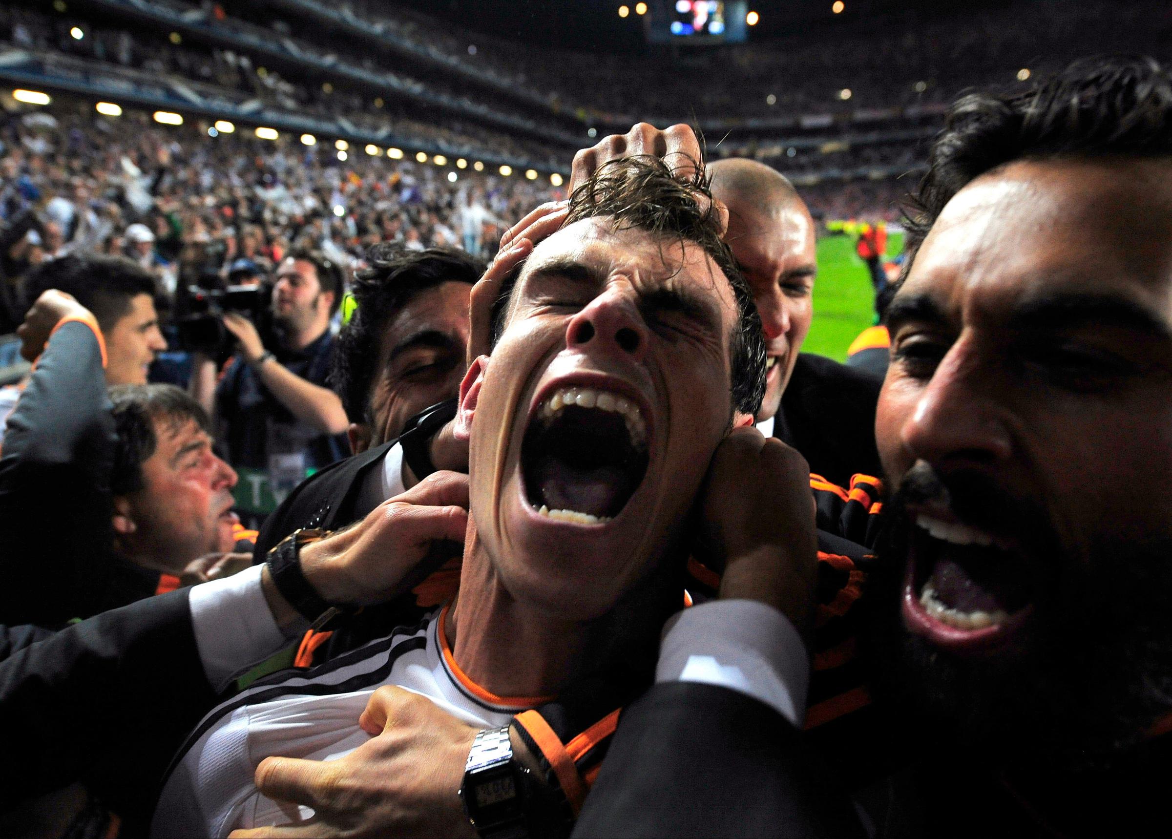 Real Madrid's Gareth Bale celebrates with teammates after scoring his second goal in the Champions League final soccer match against Atletico Madrid at the Luz Stadium in Lisbon on May 24, 2014.