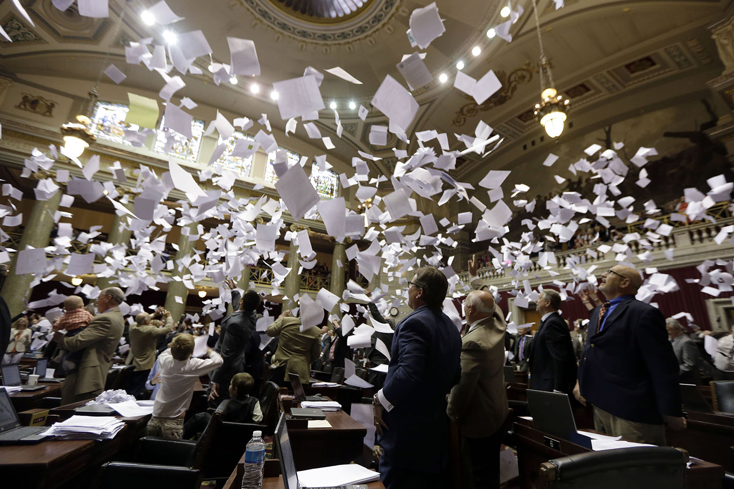 Members of the Missouri House of Representatives throw papers in the air in celebration of the end of the legislative session in Jefferson City, Mo., on May 16, 2014.