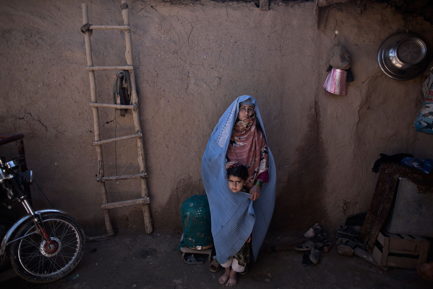 Afghan refugee Aziza Nazar, 37, a mother of 7 children, with her daughter Lal Mina, 3, at her neighbor's mud house in a slum on the outskirts of Islamabad on March 30, 2014. Nazar and her parents fled the Civil War in their village near Kabul 15 years ago.
                              
                               During the the Civil War only rich people could survive. There was fighting between groups in my village. That's why my parents decided to flee to Pakistan. I don't want my children to live [through] what I lived [through], and I can make sure of that in Pakistan.