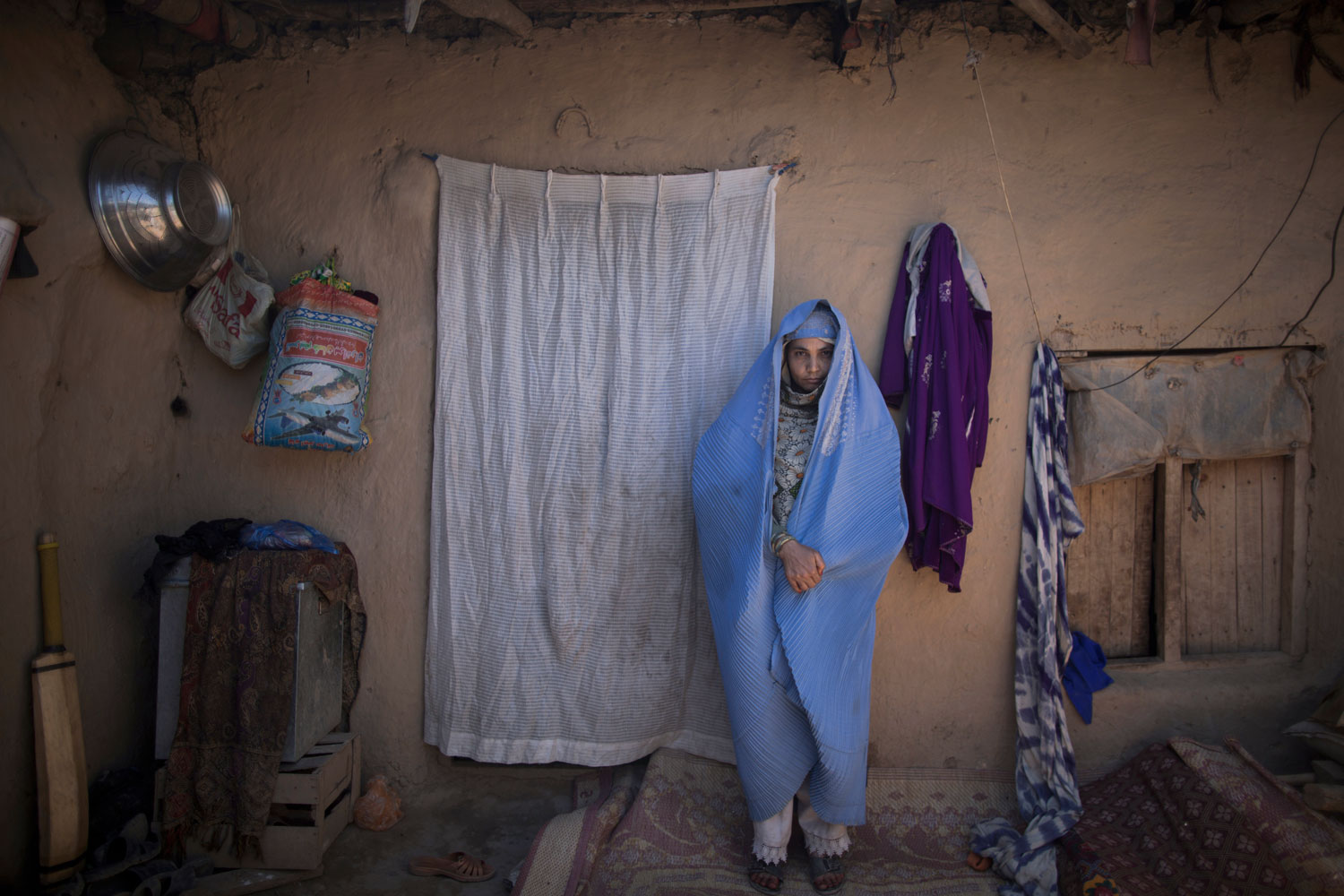 Afghan refugee Yasmina Yawaz, 30, a mother of two children, at her mud house in a slum on the outskirts of Islamabad on March 30, 2014. Yasmina and her husband fled the violence in Jalalabad a year ago, following the death of her brother.