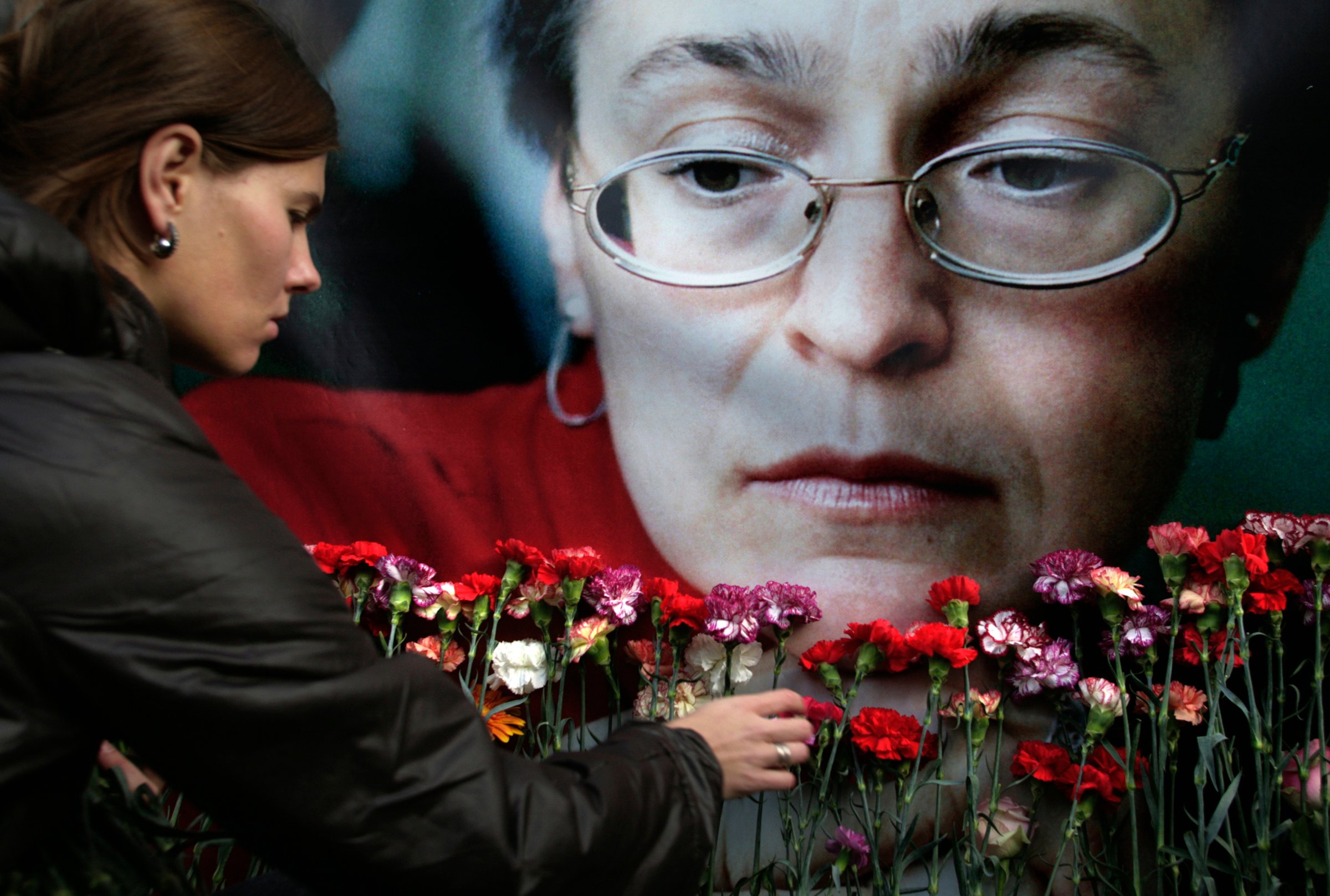 A woman places flowers at a portrait of slain journalist Anna Politkovskaya, during a rally in downtown Moscow, in 2009.