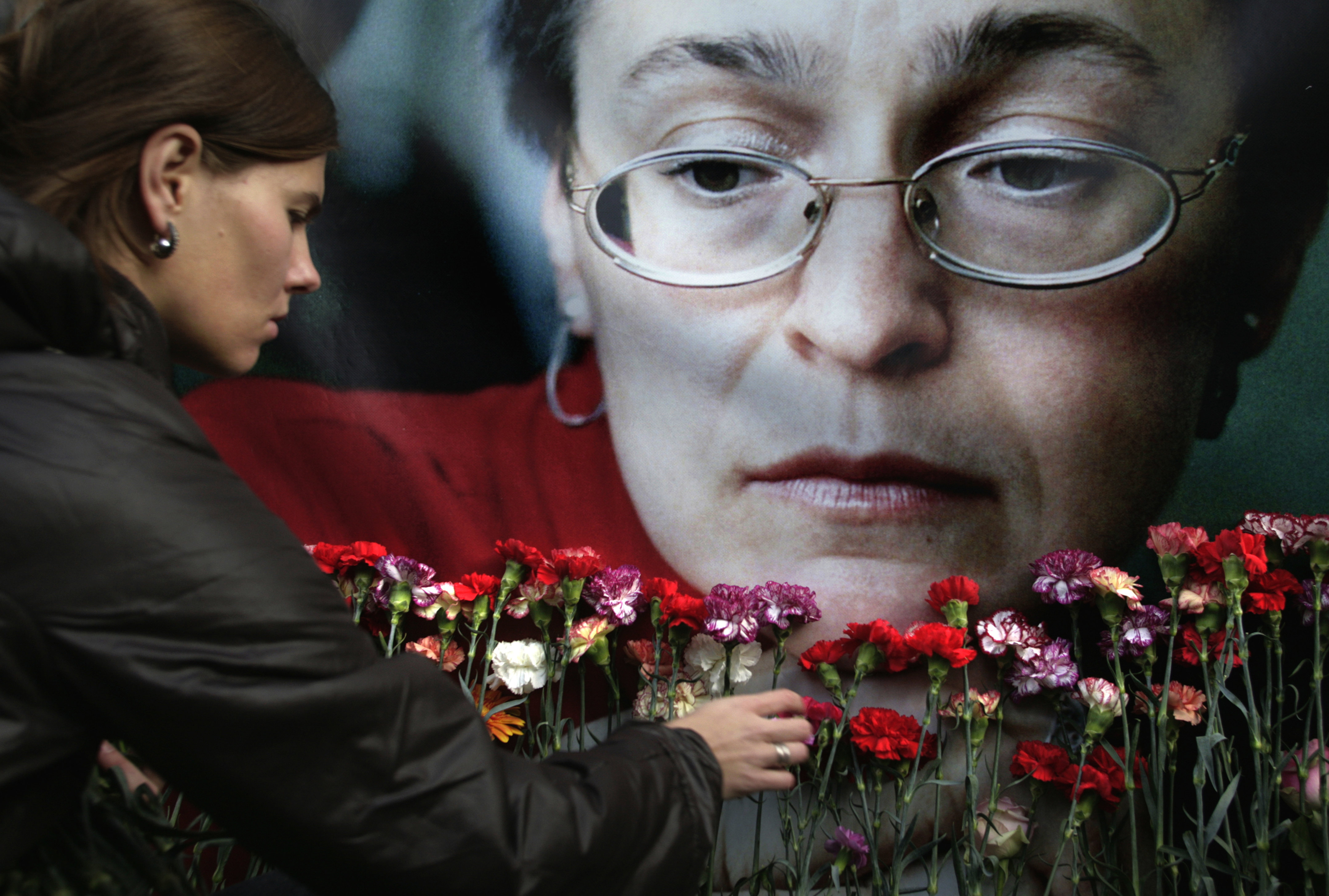A woman places flowers at a portrait of slain journalist Anna Politkovskaya, during a rally in downtown Moscow, in 2009. (Pavel Golovkin—AP)