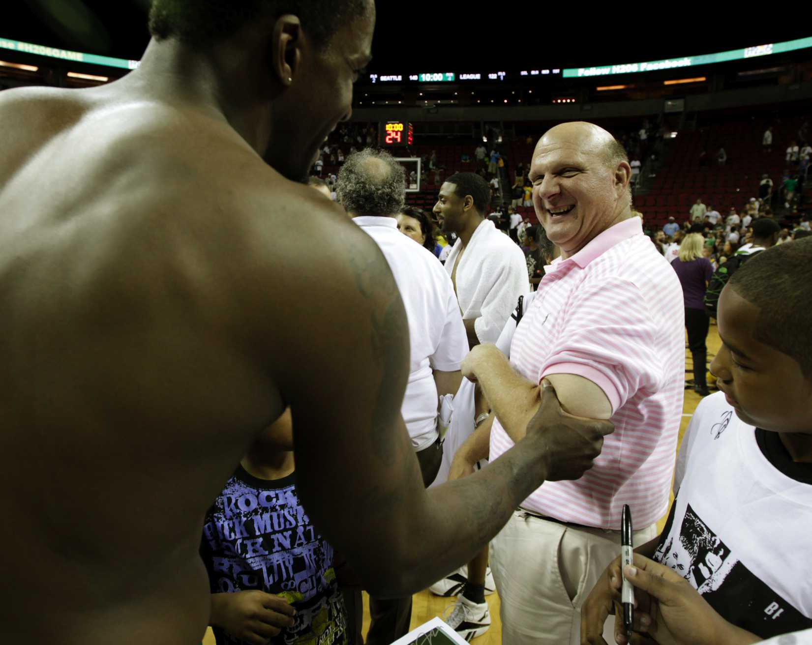 Microsoft Corp. CEO Steve Ballmer, right, reacts as Martell Webster, left, of the NBA's Minnesota Timberwolves, checks the size of Ballmer's bicep, following a charity basketball game, Saturday, July 23, 2011, in Seattle. (Ted S. Warren—AP)