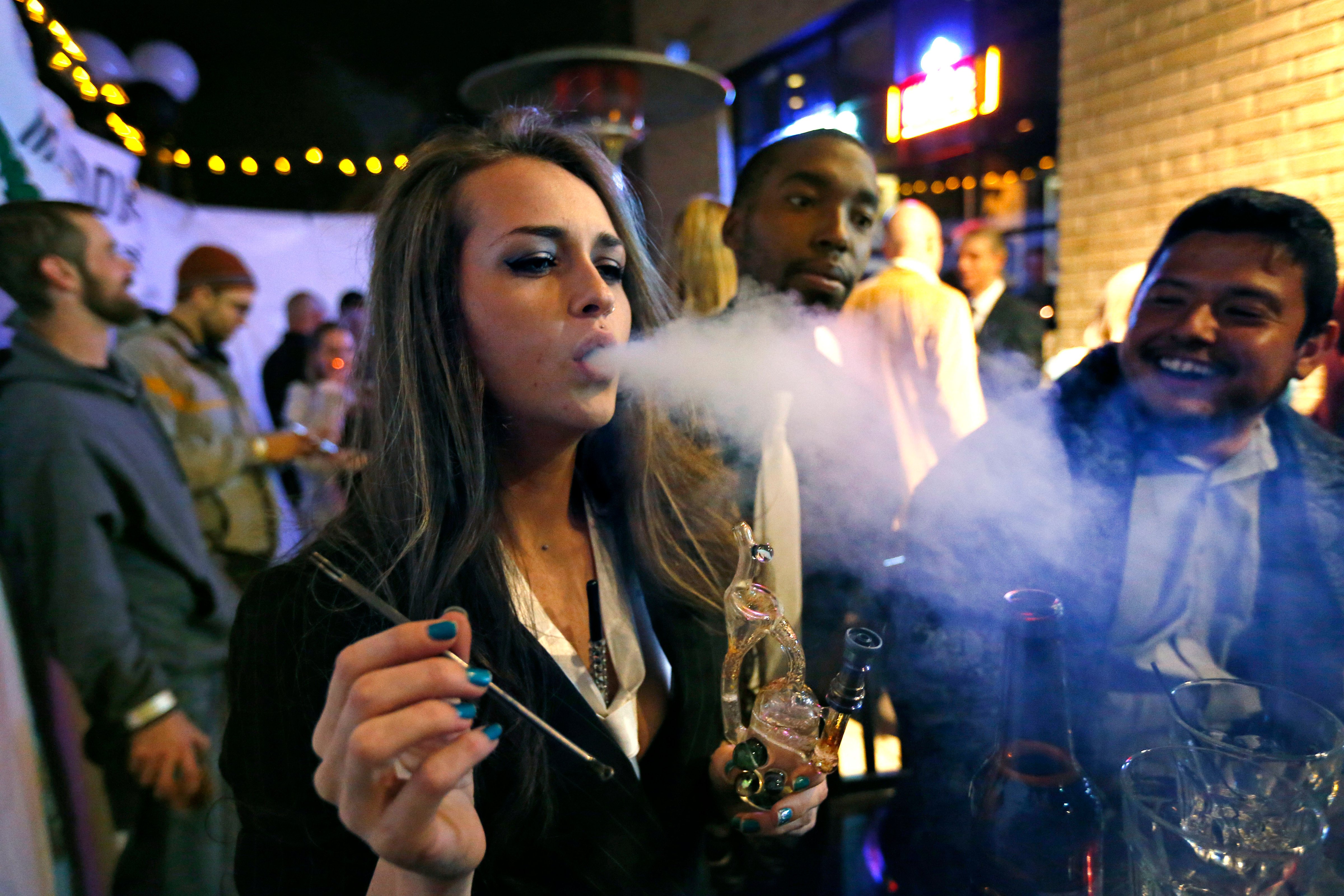 Partygoers smoke marijuana during a New Year's Eve party at a bar in Denver, celebrating the 2014 start of retail pot sales in Colorado. (Brennan Linsley—AP)