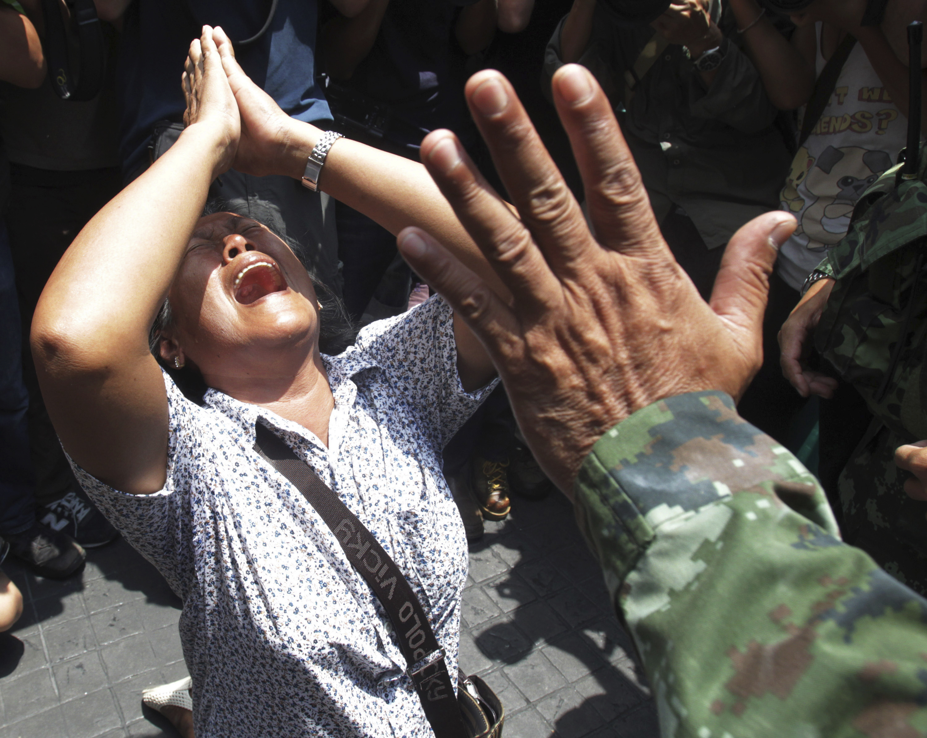 An anticoup protester cries as she pleads with a soldier to leave during a demonstration in Bangkok on May 25, 2014 (Sakchai Lalit—AP)