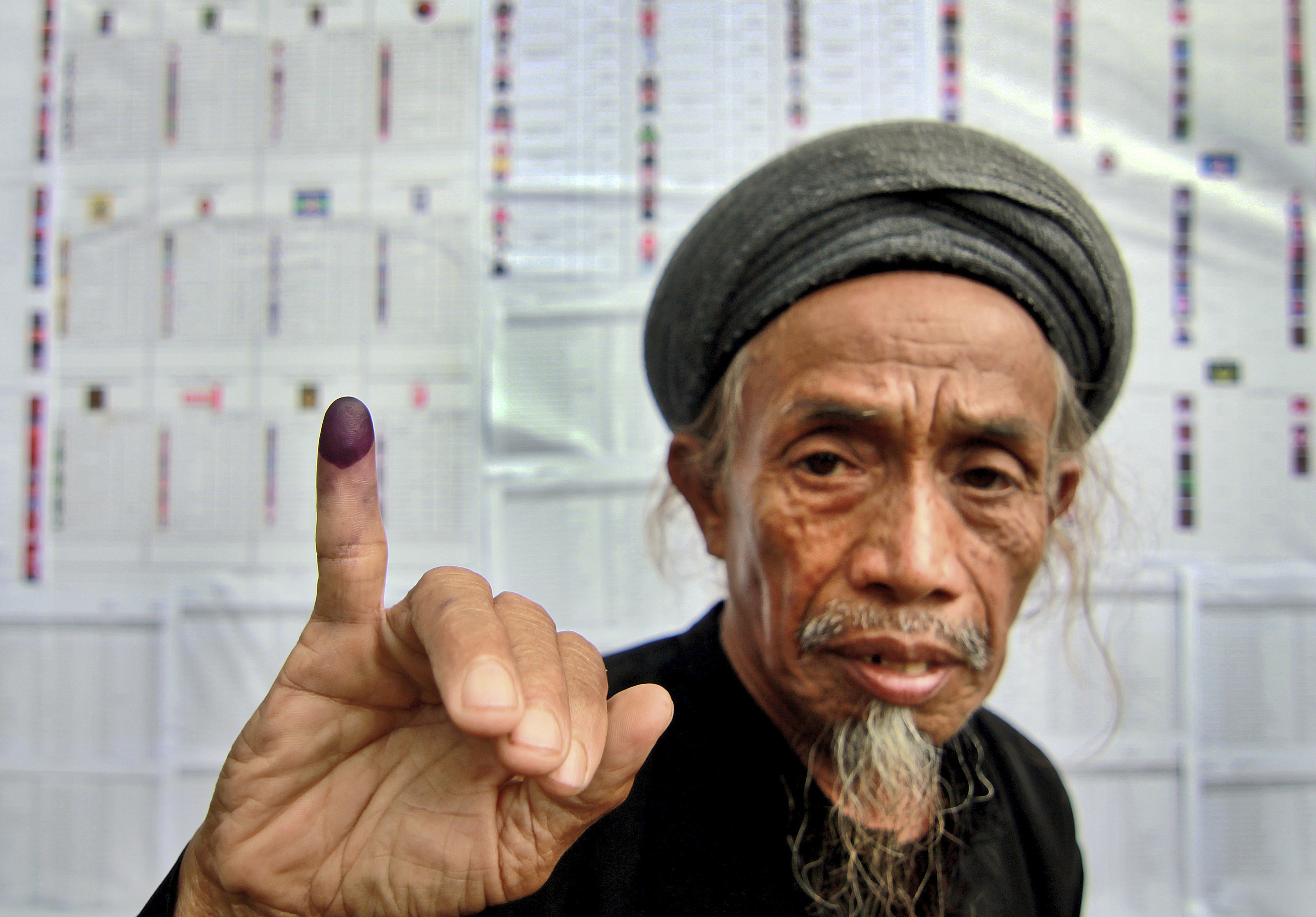 A member of the An-Nadzir Muslim sect shows his inked finger after casting his ballot at a polling station during the Indonesian parliamentary elections in Gowa, South Sulawesi province, on April 9, 2014 (Masyudi S. Firmansyah&mdash;AP)