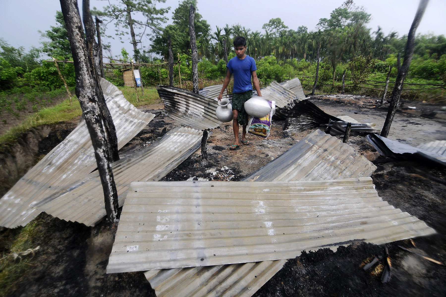 An Indian resident salvages valuables in the remains of his house in the village of Khagrabari, some 200 km west of Guwahati on May 3, 2014, after it was attacked by tribal separatists in India's remote northeastern state of Assam (Biju Boro—AFP/Getty Images)