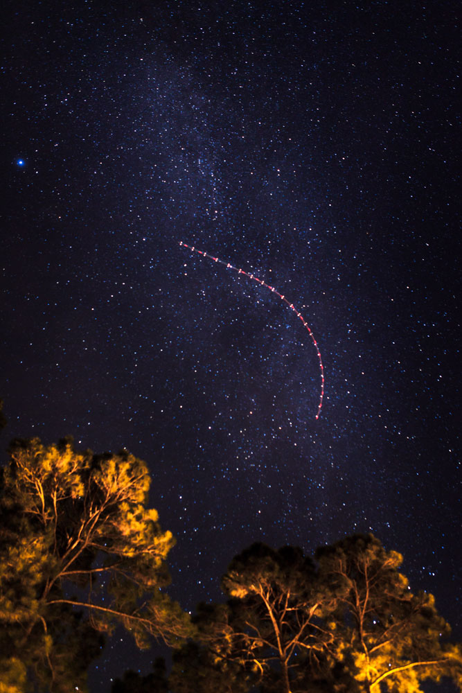 An aircraft turns over the night sky with the Milky Way in the background above Santa Rosa Beach, Fla., on Jan. 5, 2014.