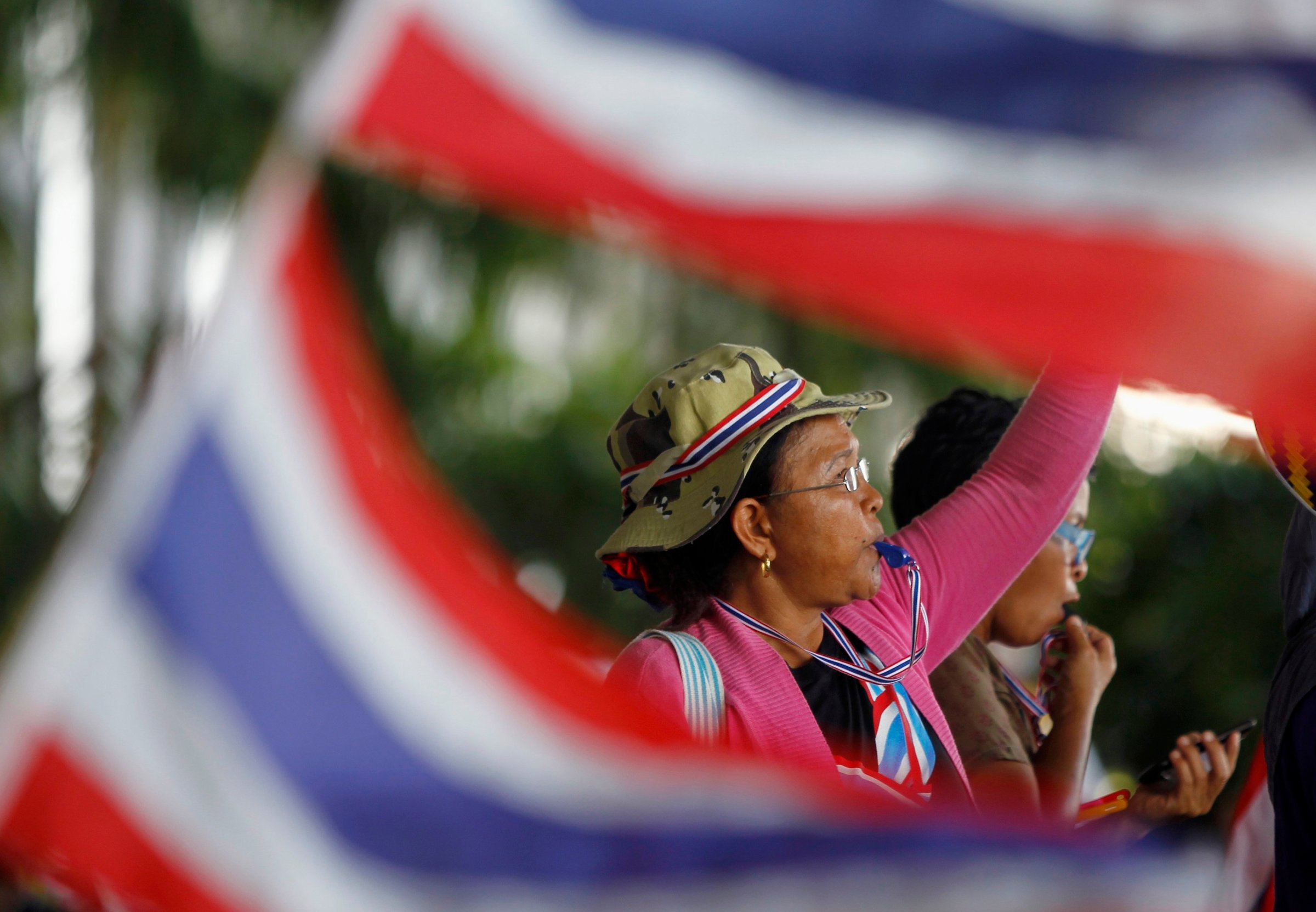 An anti-government protester blows her whistle during a rally outside the office of Election Commission in Bangkok May 15, 2014.
