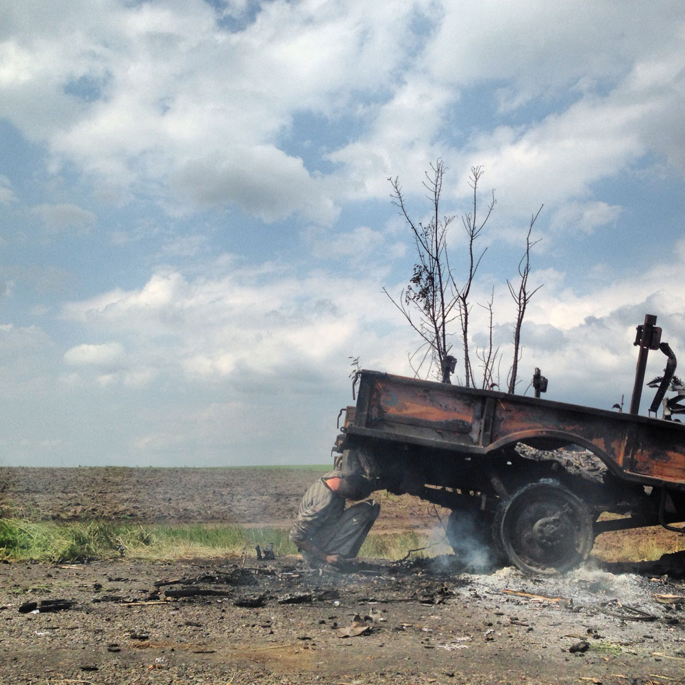 May 14, 2014. A man salvages scrap copper and other valuable metals from a Ukrainian military truck which was destroyed the day before in an ambush attack by pro-Russian militants in Kramatorsk, Ukraine.