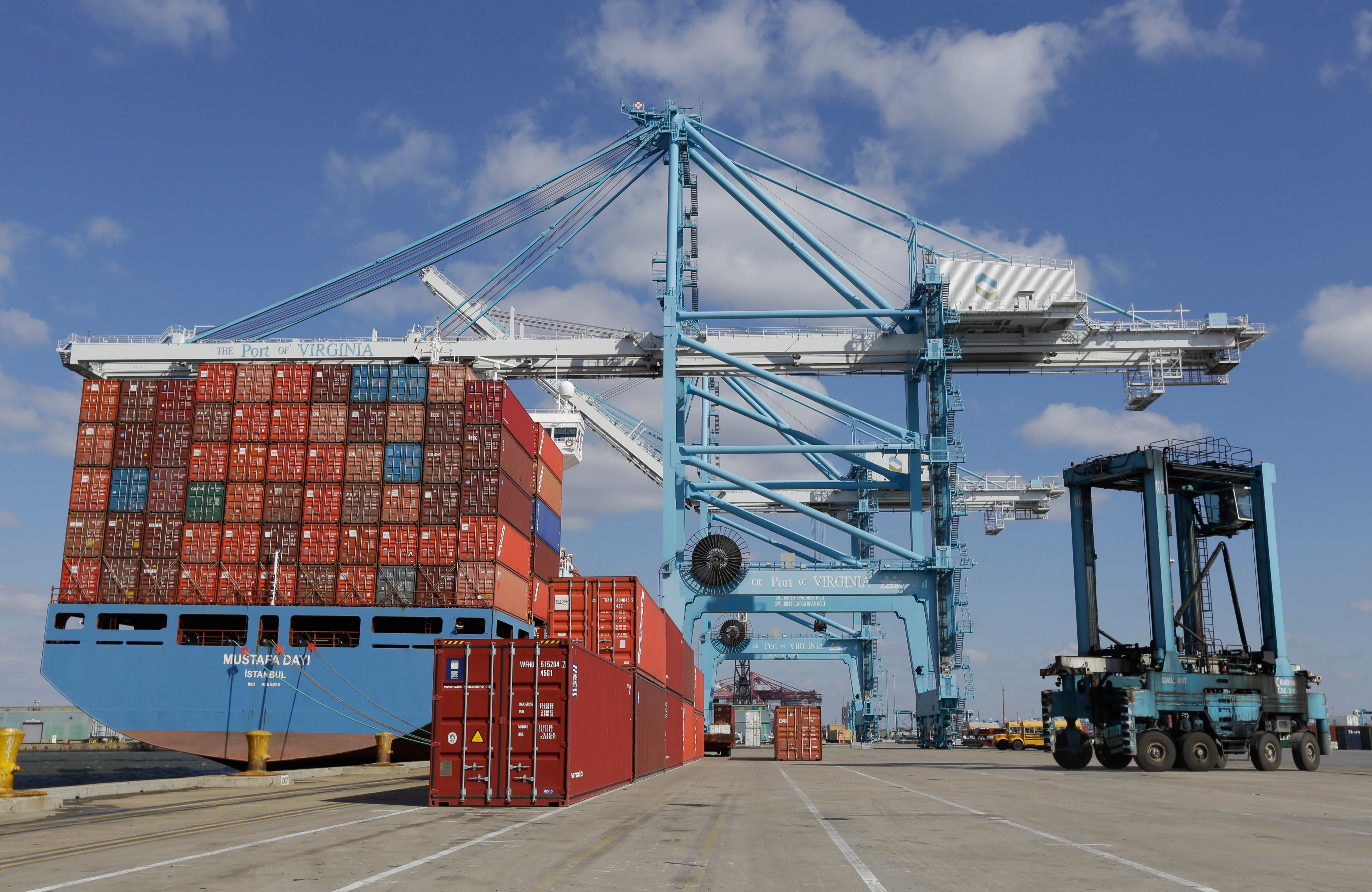 A rail mounted gantry crane, center, as well as a Straddle Carrier, right, used to unload and load a container ship at the Norfolk International Terminal in Norfolk, Va. on March 26, 2014. (Steve Helber—AP)