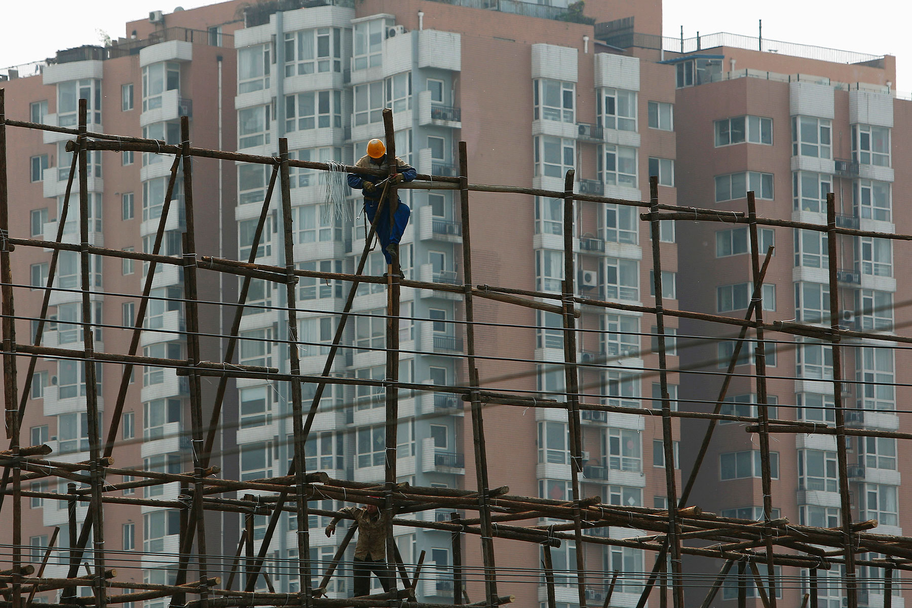 A laborer works on the scaffolding of a construction site for a new residential building in Beijing on May 8, 2014 (Kim Kyung-Hoon—Reuters)