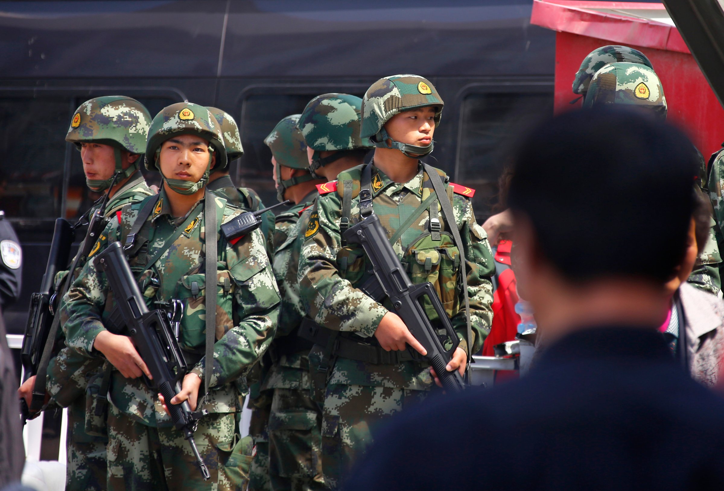 Paramilitary policemen stand guard near the exit of the South Railway Station in Urumqi, Xinjiang.