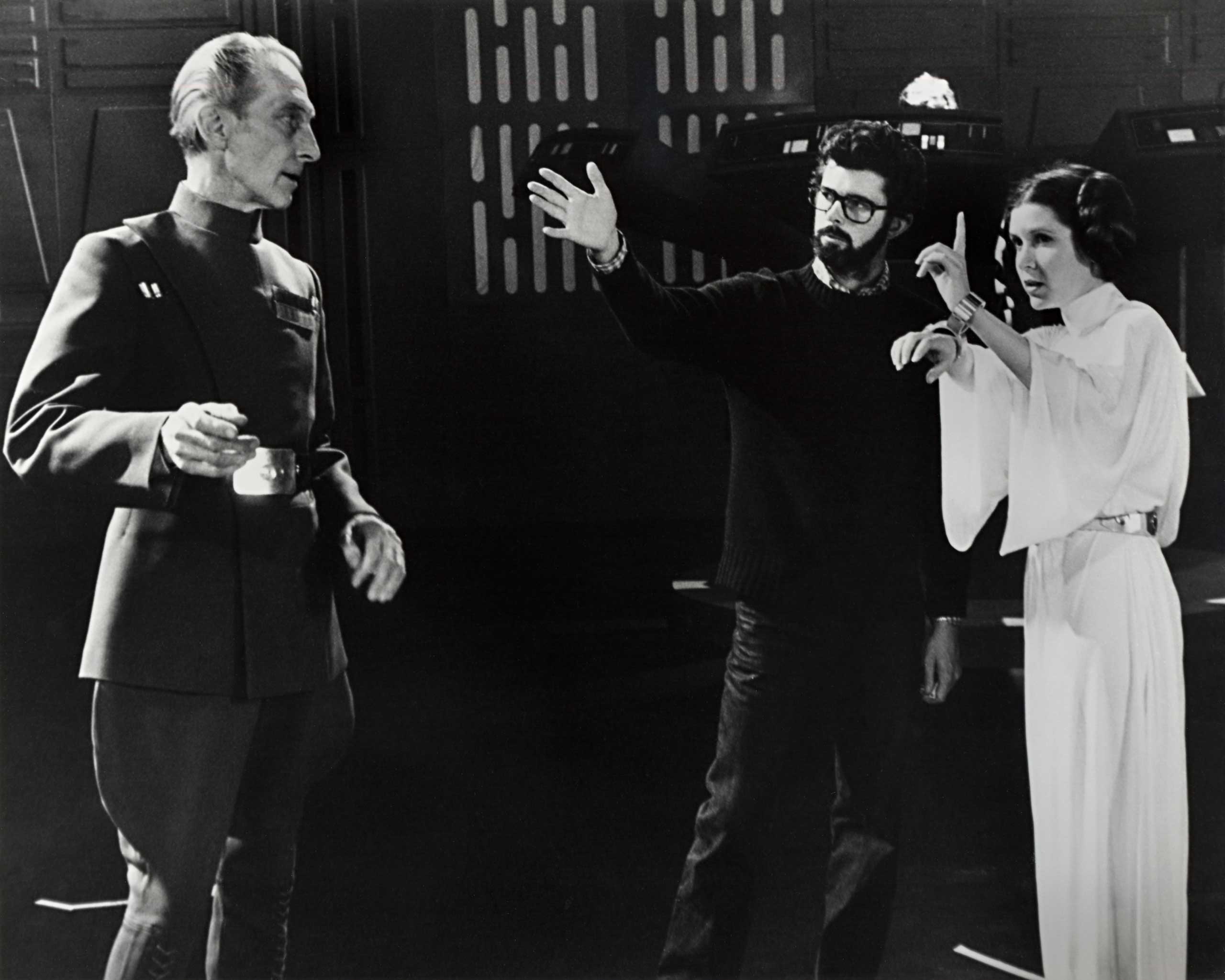 Lucas directs Peter Cushing (Grand Moff Tarkin) and Carrie Fisher.